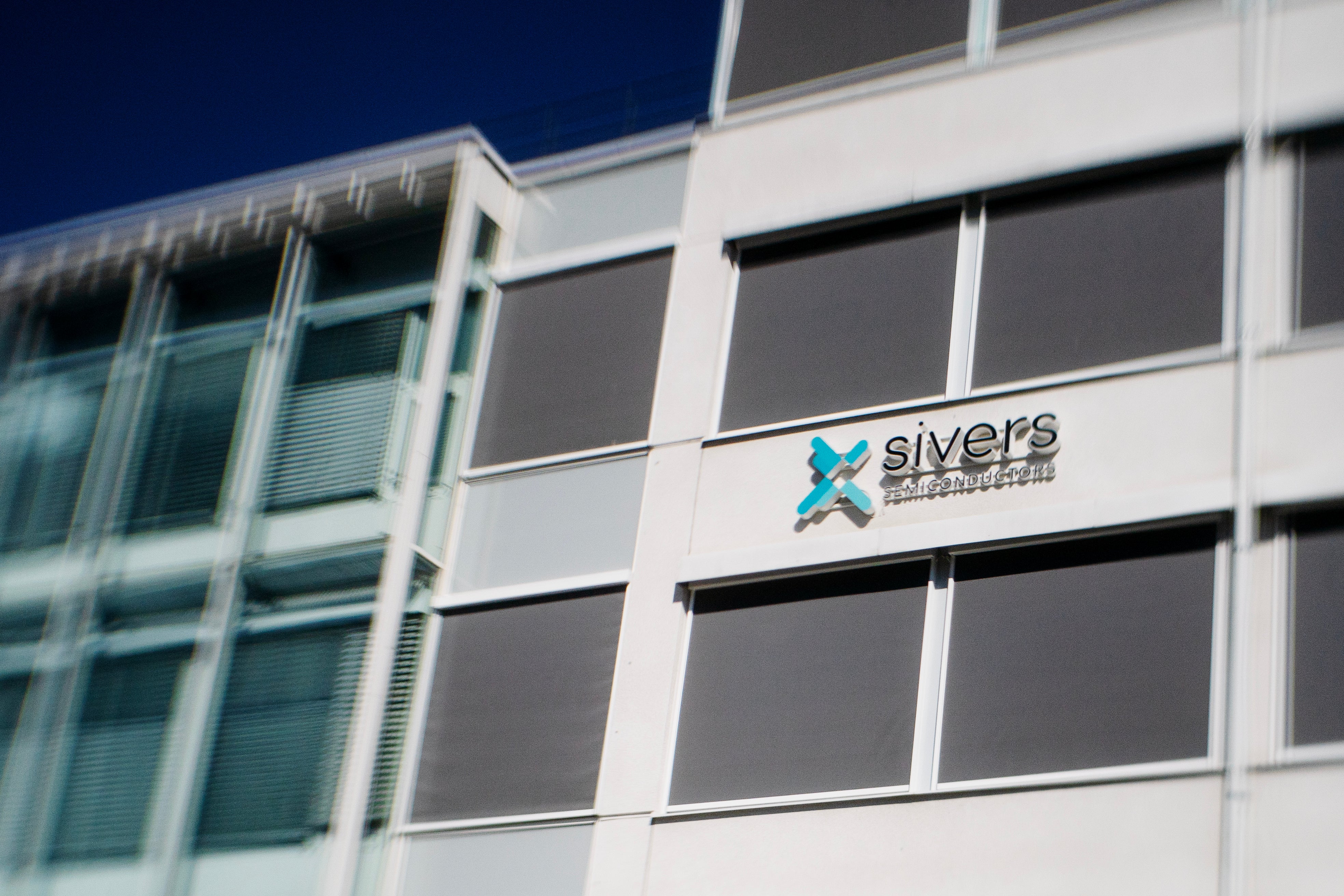 Moderna kontorsbyggnad med Sivers-logotyp på vit vägg