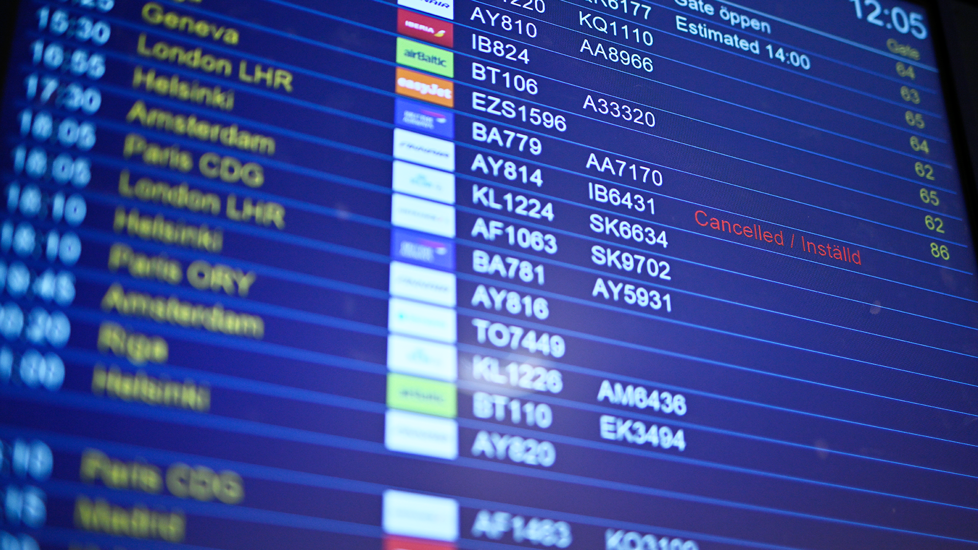 En flygavgångstavla på en flygplats som visar information om olika flyg, inklusive destinationer, flygnummer och status.