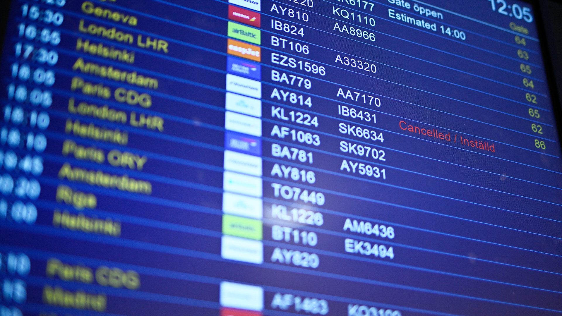 En flygavgångstavla på en flygplats som visar information om olika flyg, inklusive destinationer, flygnummer och status.