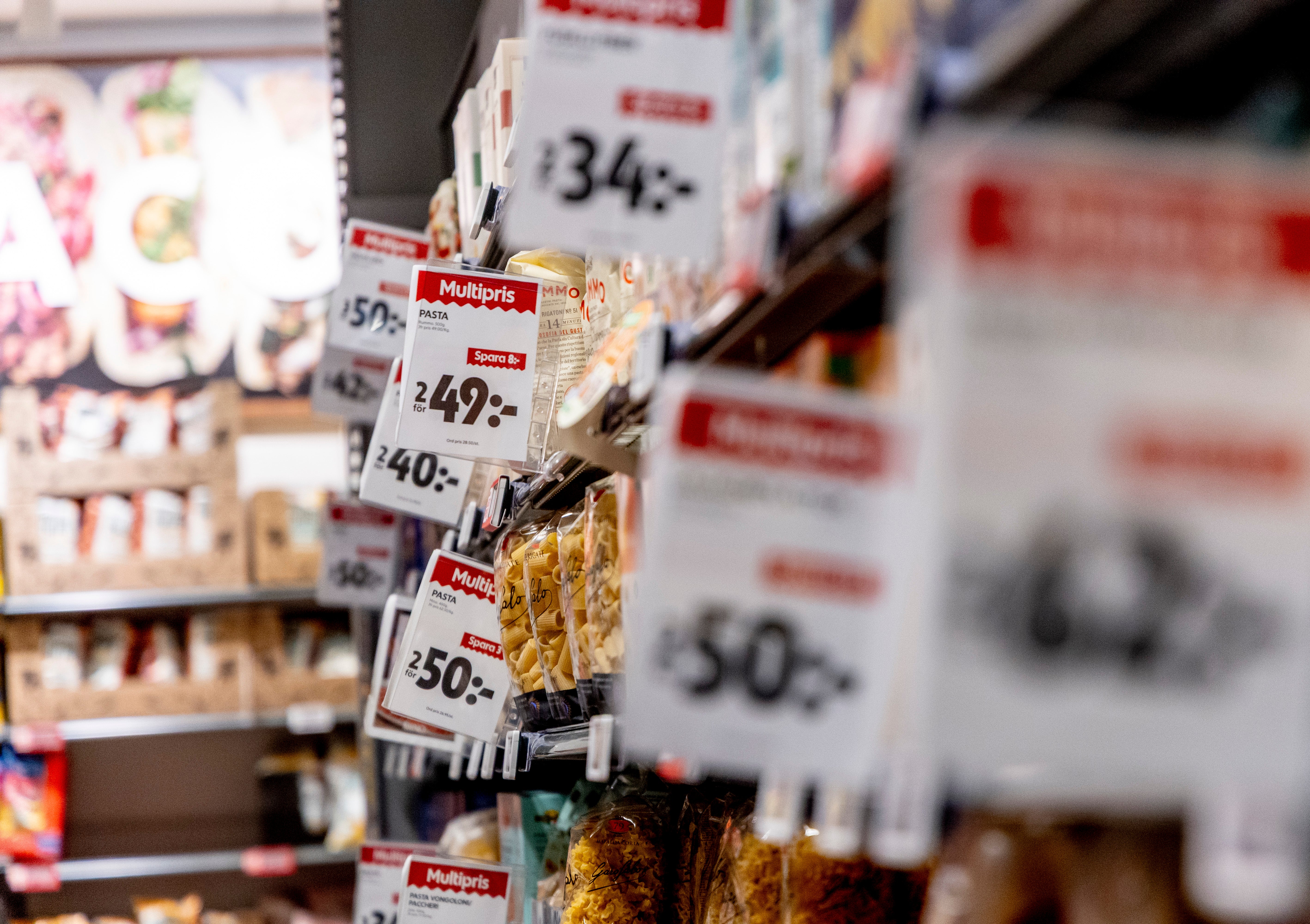 Närbild av matvaror på en butikshylla med röda prisetikett som visar priser på svenska kronor.