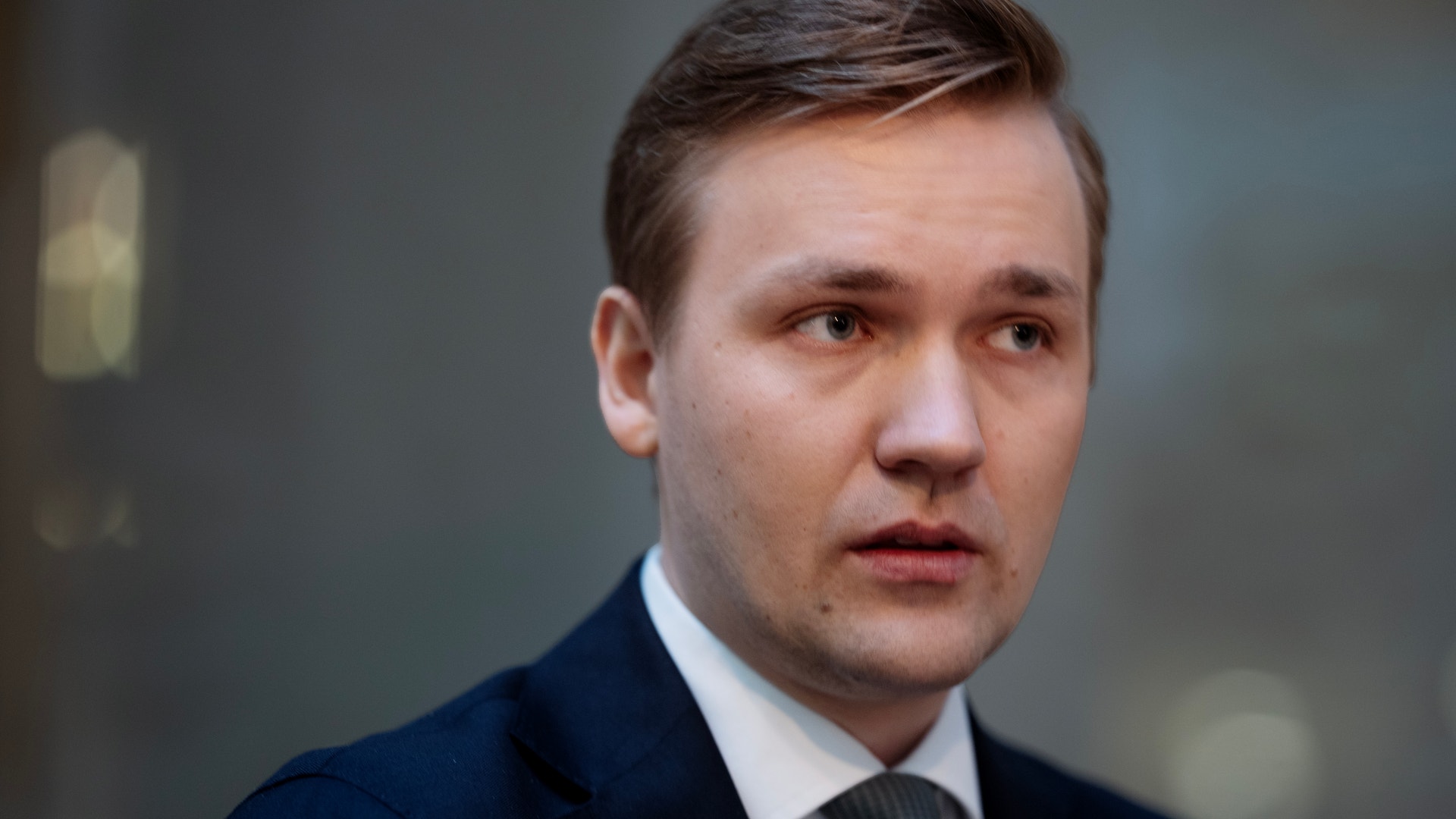 Porträtt av en man i mörkblå kostym och slips