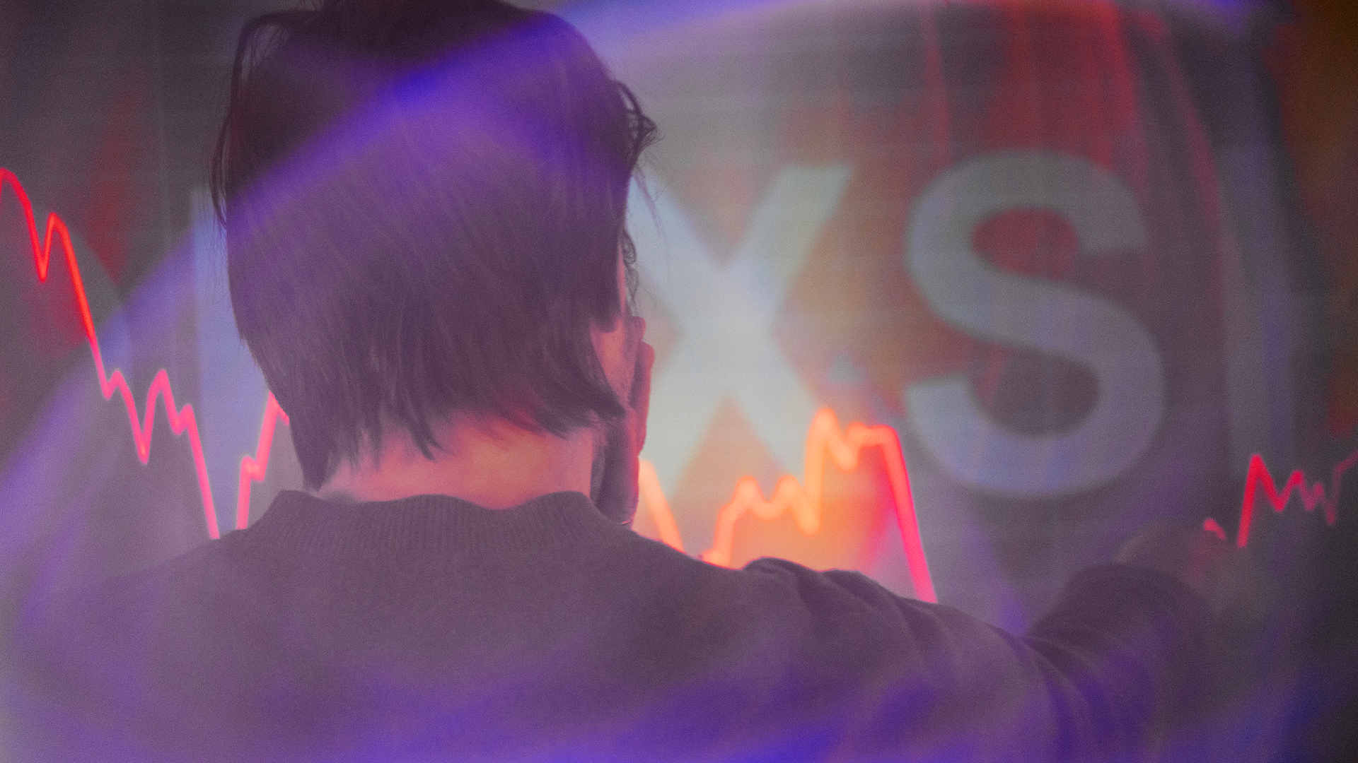 Person tittar på börsdata med fallande aktiekurser