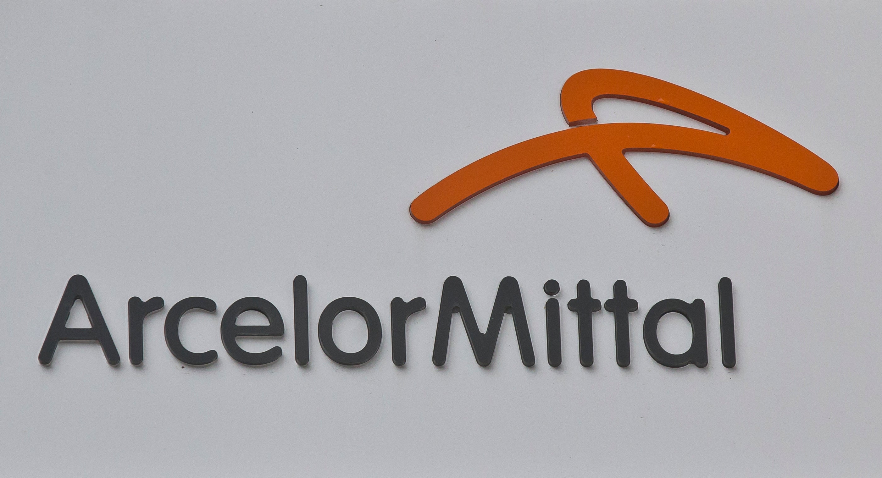 ArcelorMittal logotyp med orange symbol och företagsnamn i mörkgrå text