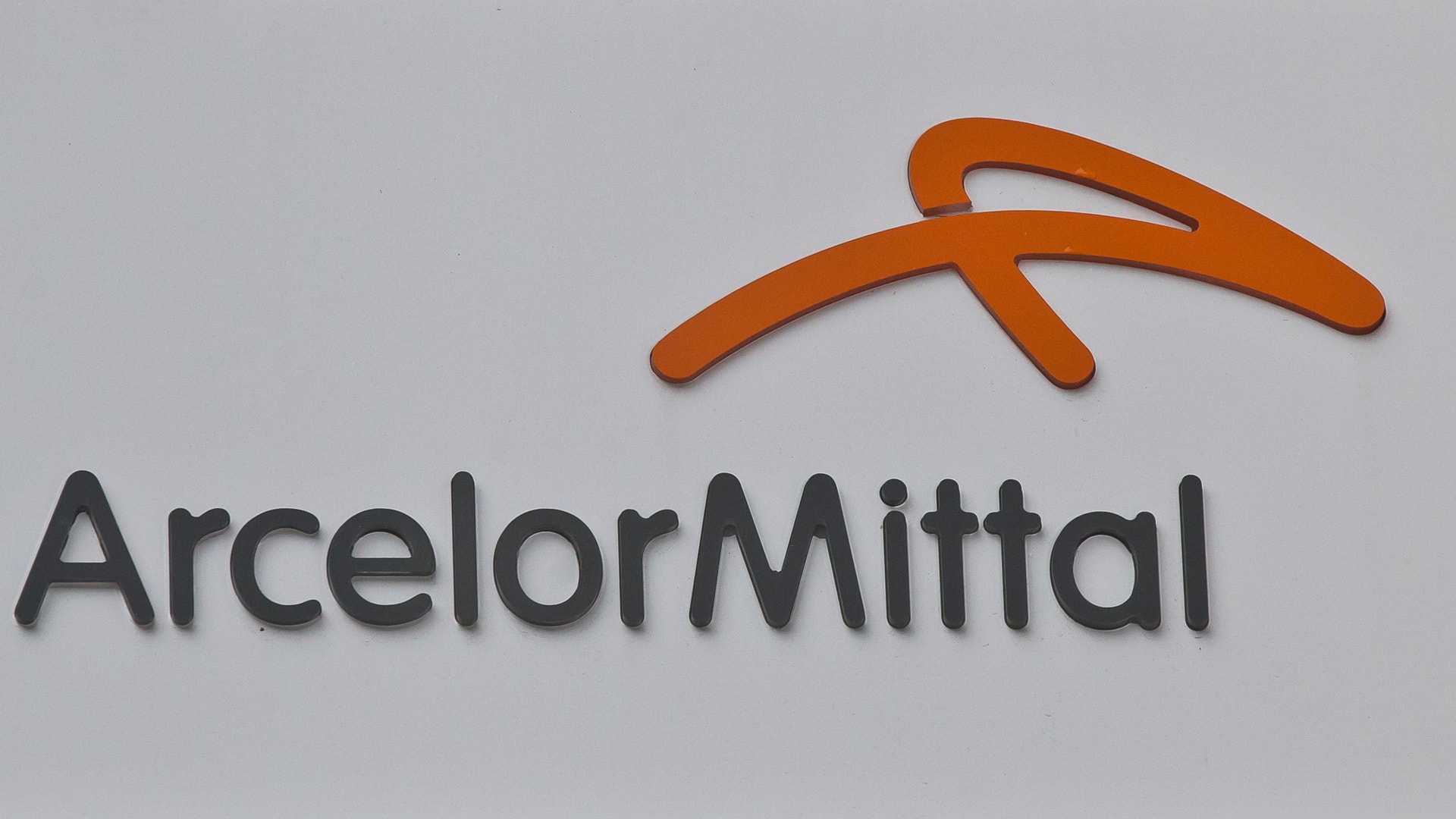 ArcelorMittal logotyp med orange symbol och företagsnamn i mörkgrå text