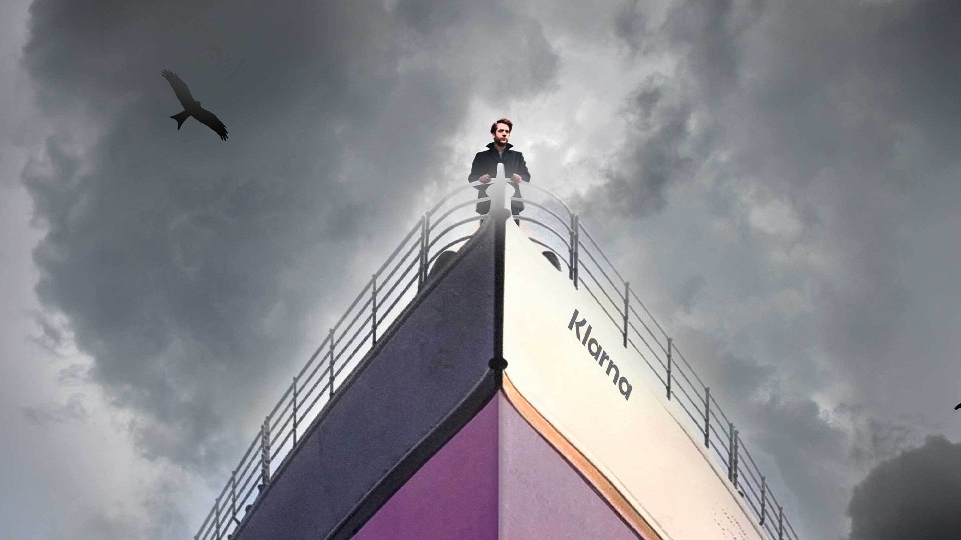 En man står högt uppe på fören av ett fartyg som liknar Titanic, med texten "Klarna" på skrovet, mot en mulen himmel.