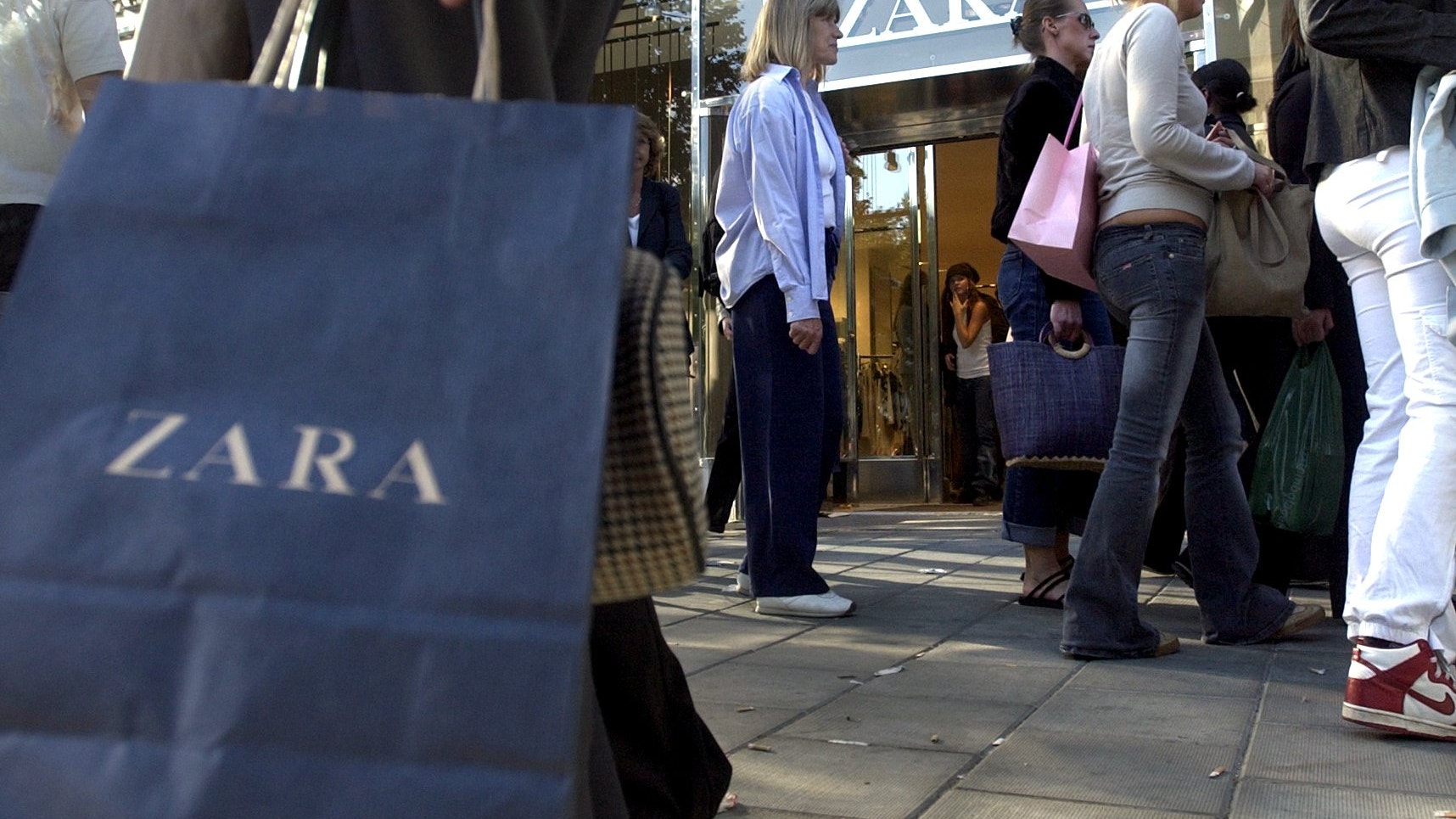 Kunder med shoppingväskor utanför en Zara-butik