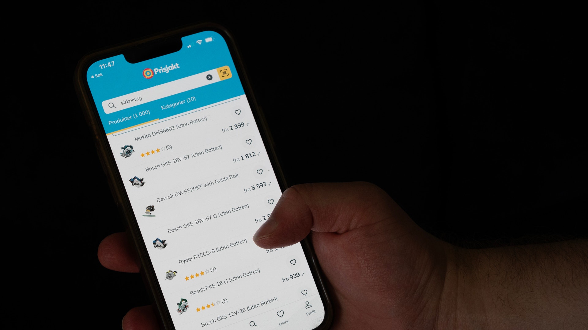 En hand håller en mobiltelefon som visar Prisjakts app med en lista över produkter.