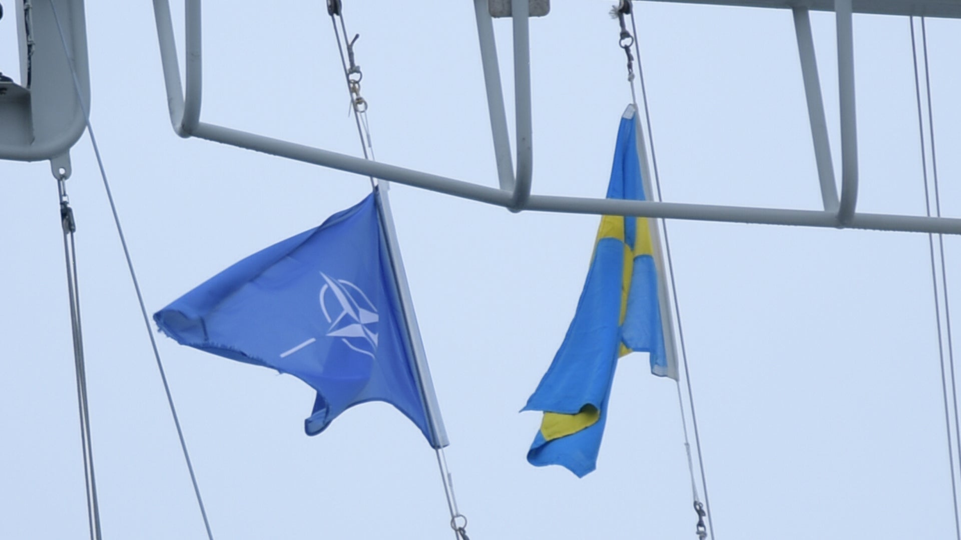 NATO-flagga och svensk flagga hängande på ett fartyg