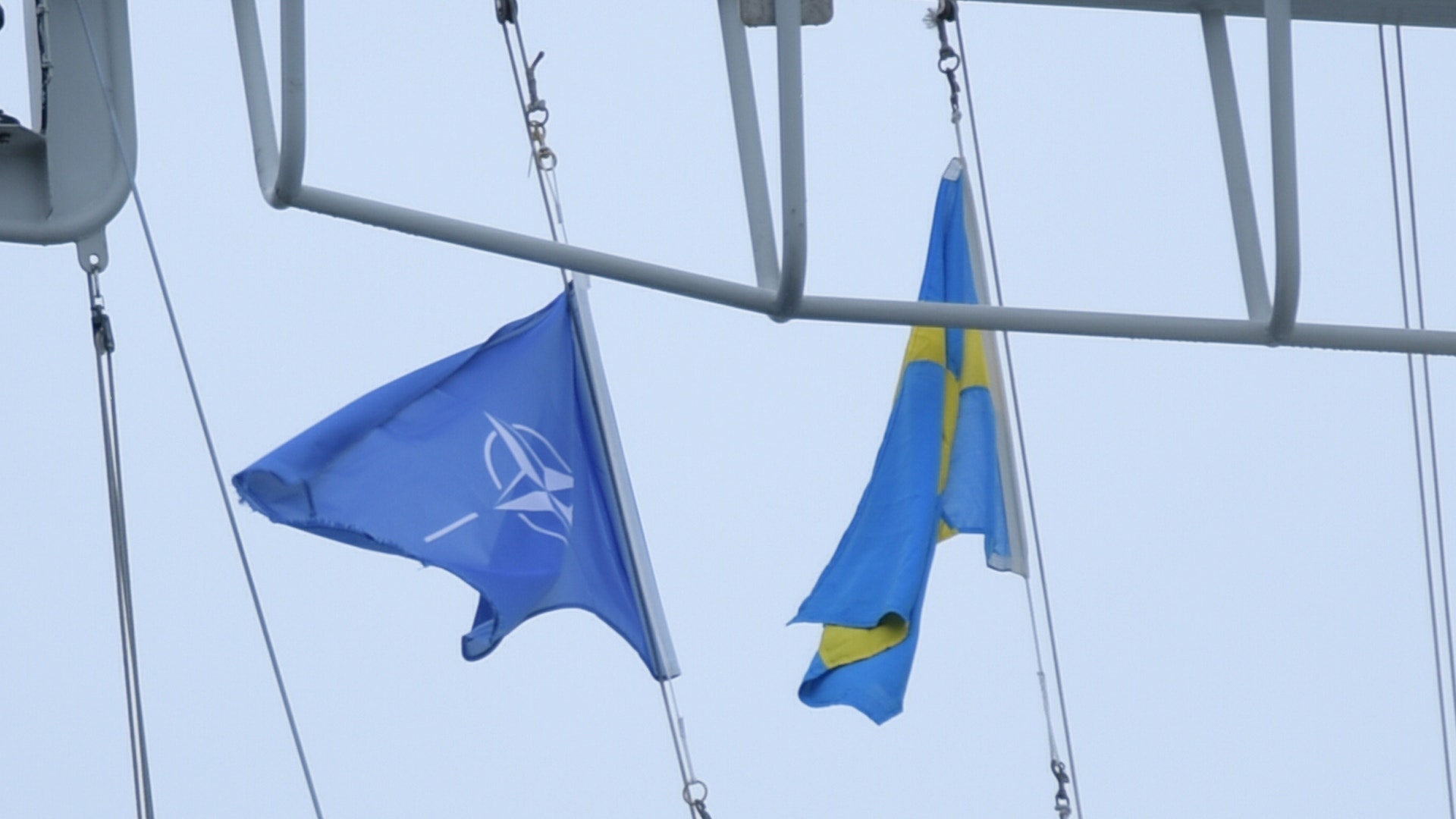 NATO-flagga och svensk flagga hängande på ett fartyg