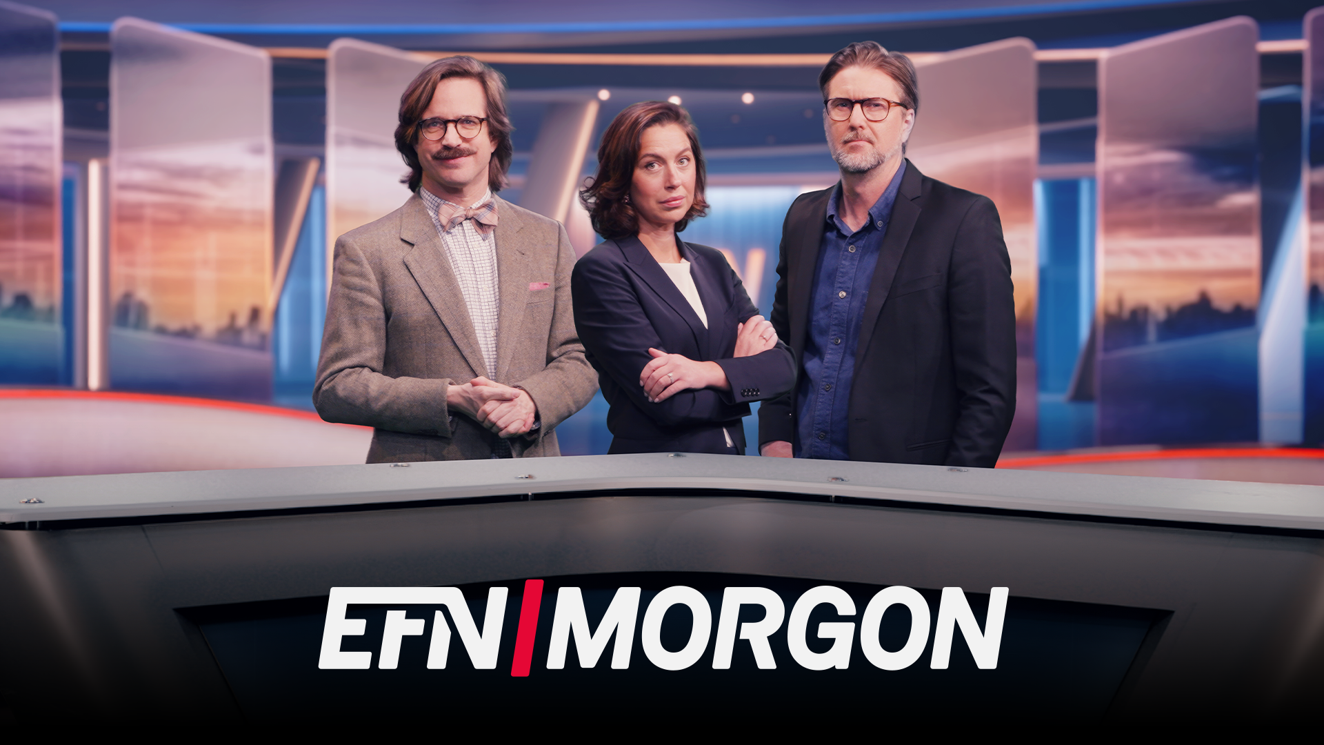 Tre nyhetspresentatörer står vid ett nyhetsbord i en TV-studio. I bakgrunden syns en stadshorisont vid solnedgång. Texten EFN MORGON visas längst ner på bilden.