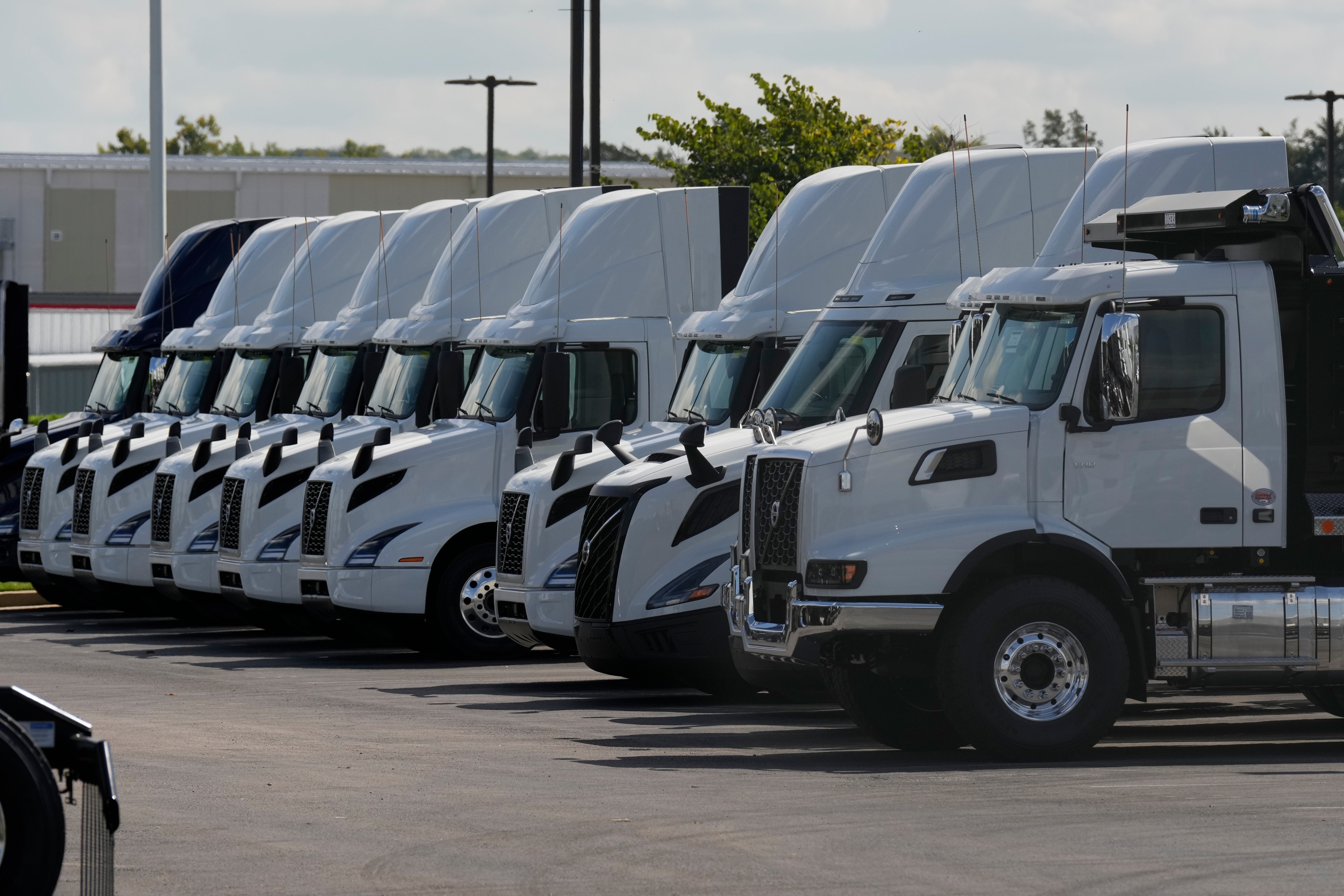 En rad vita lastbilar parkerade på en transportterminal