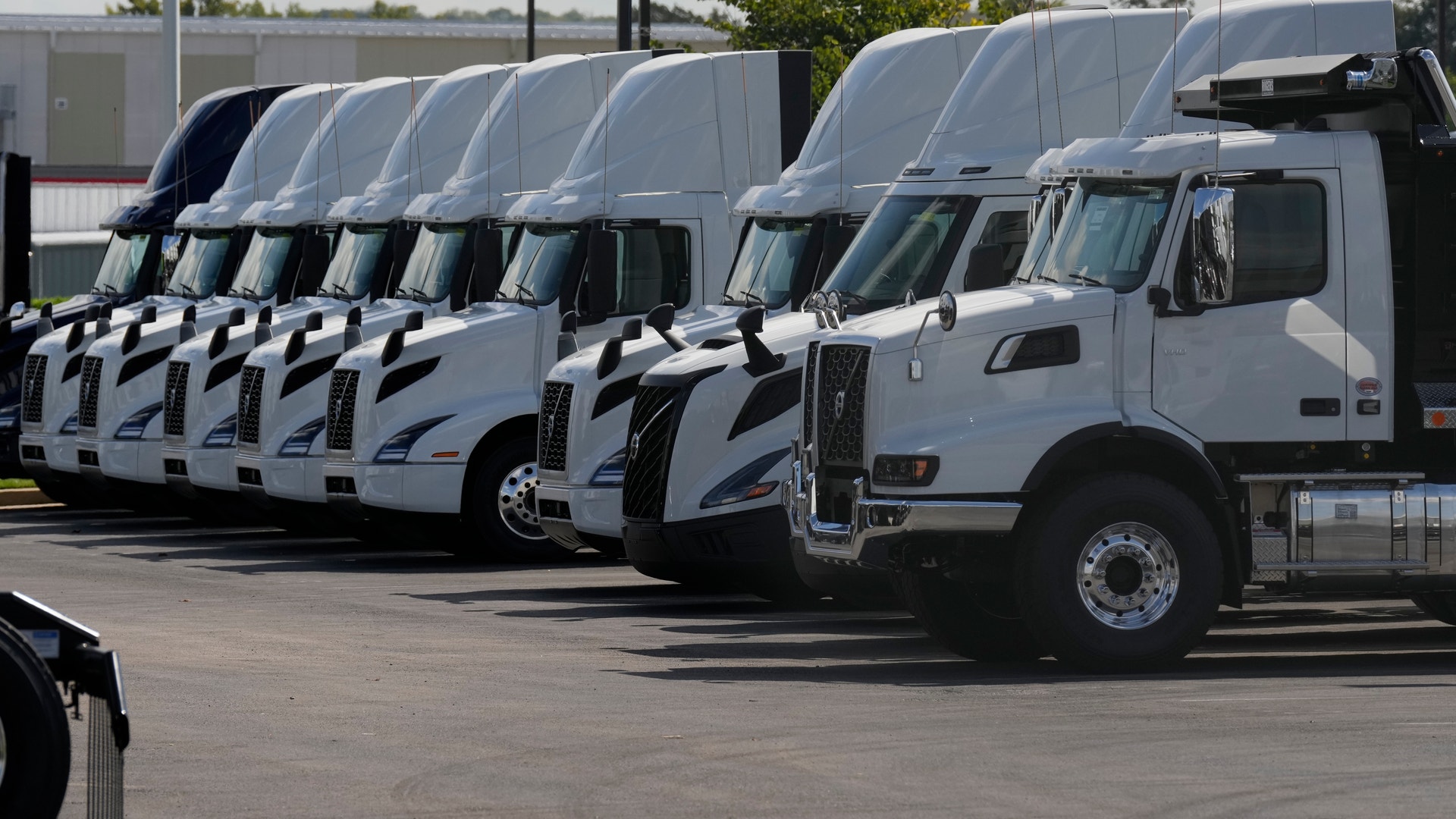 En rad vita lastbilar parkerade på en transportterminal