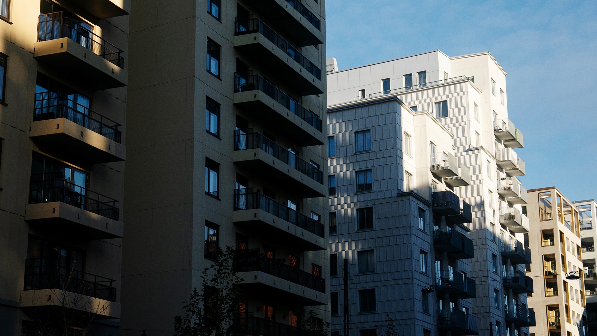 Moderna flerbostadshus med balkonger under blå himmel