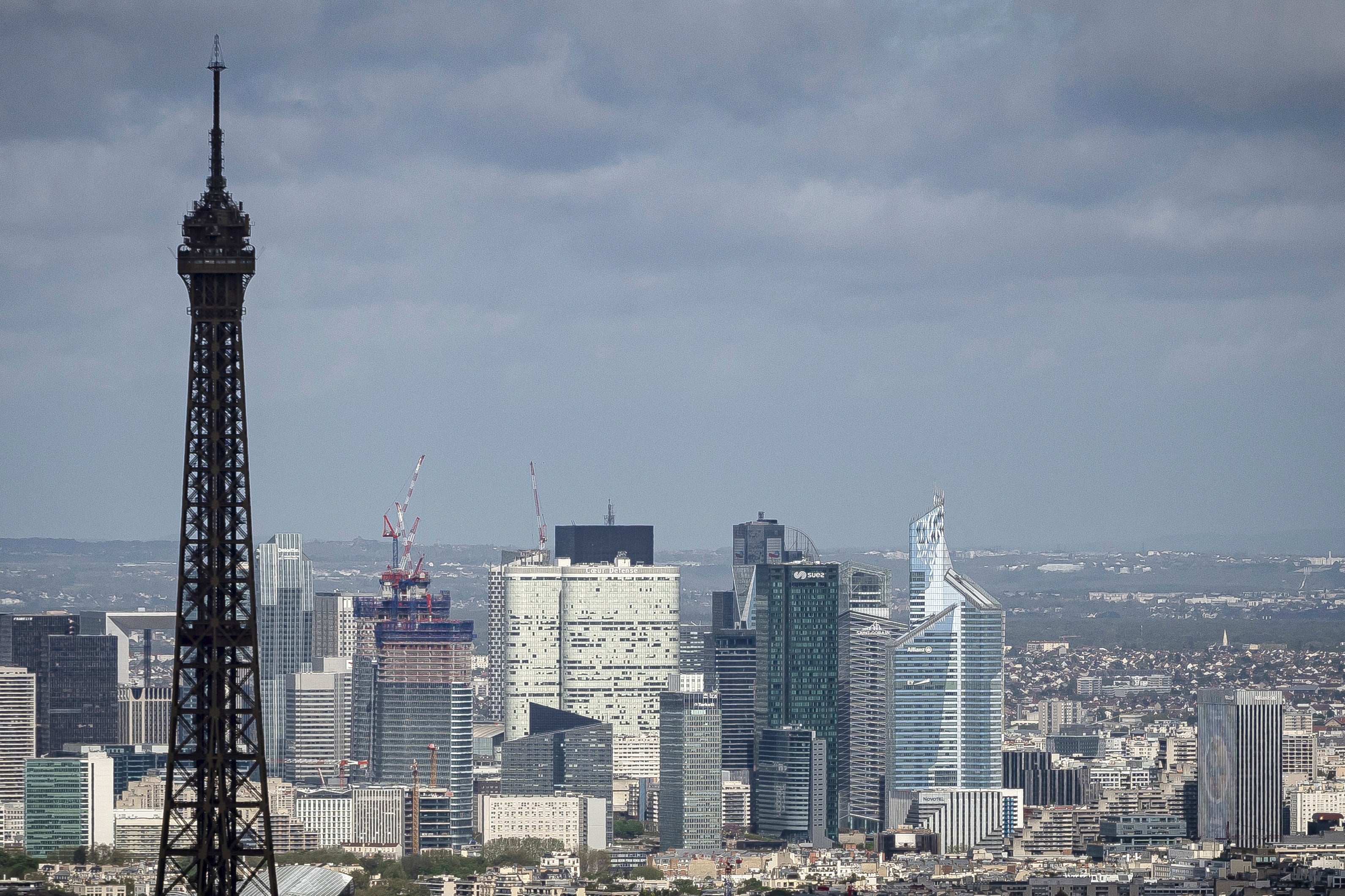 Eiffeltornet och skyskraporna i affärsdistriktet La Défense i Paris, sedda över stadens hustak.