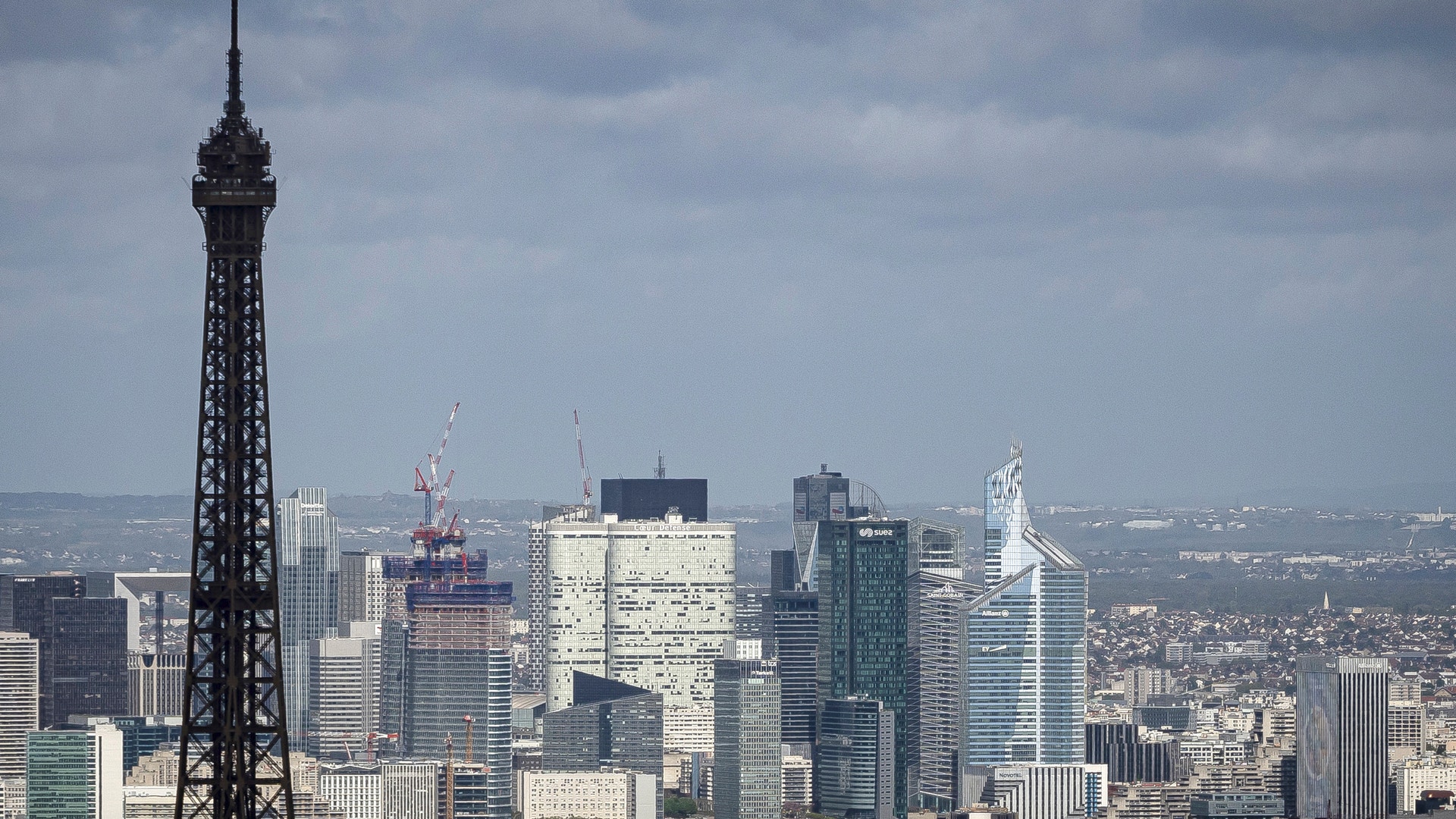 Eiffeltornet och skyskraporna i affärsdistriktet La Défense i Paris, sedda över stadens hustak.