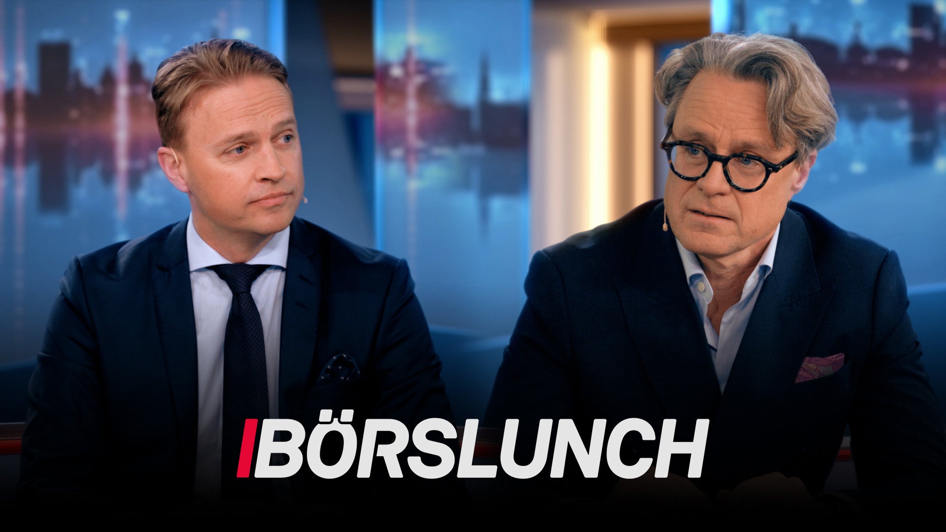 Två män i affärskläder sitter i en TV-studio med stadsvy i bakgrunden. Texten "BÖRSLUNCH" visas längst ned på skärmen.