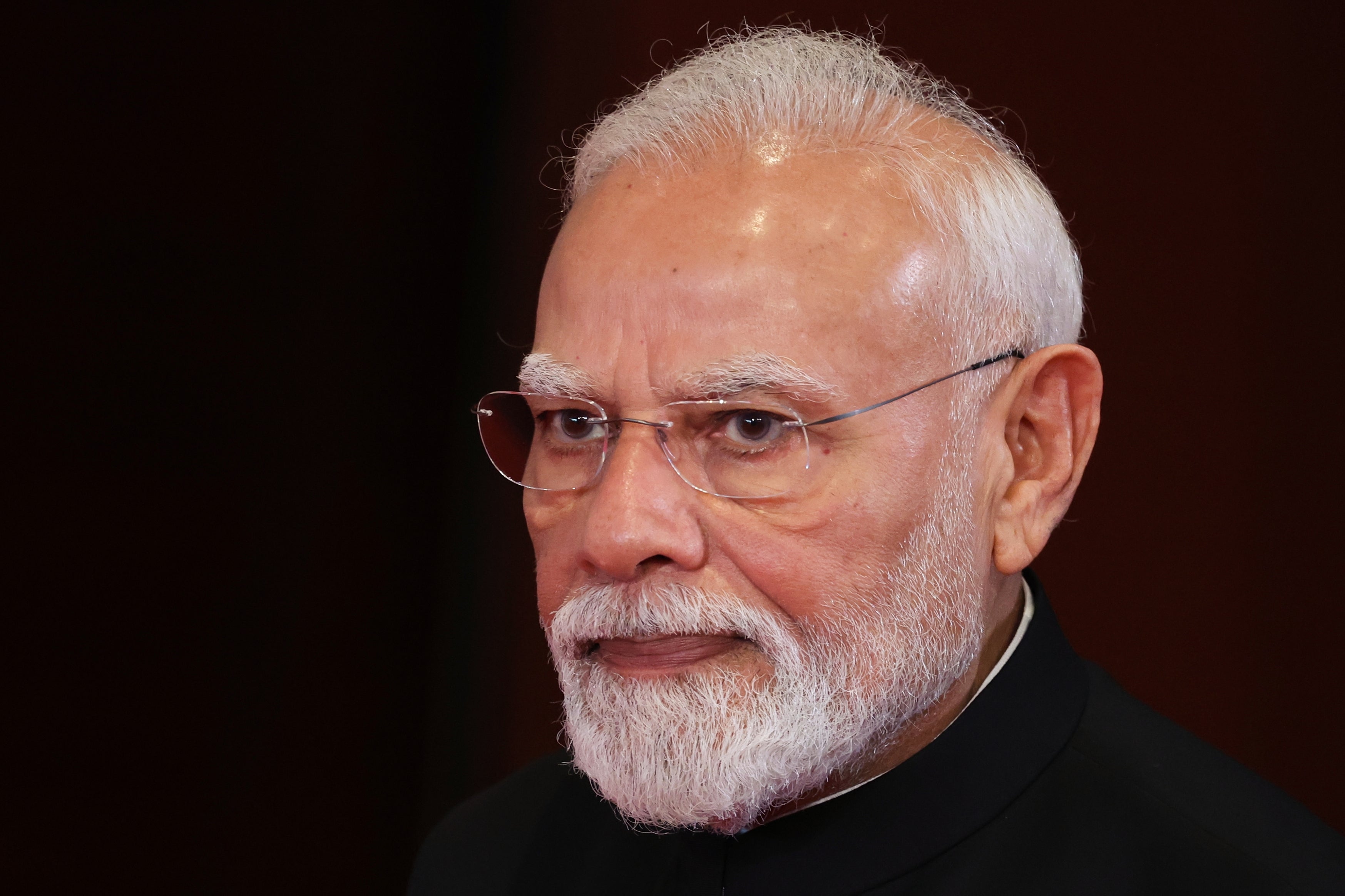 Närbild av Narendra Modi, en äldre man med vitt hår och skägg, glasögon och mörk jacka.