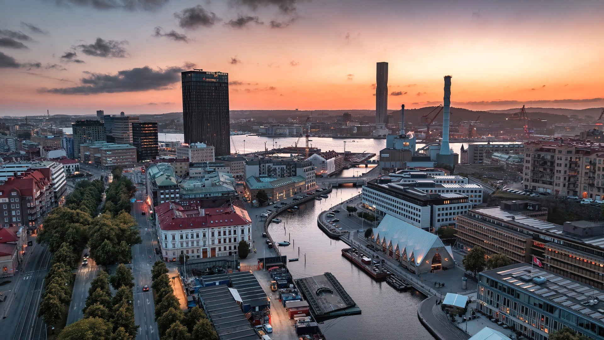 Solnedgång över Göteborg med utsikt över älven, moderna byggnader och stadslandskapet vid skymningen.