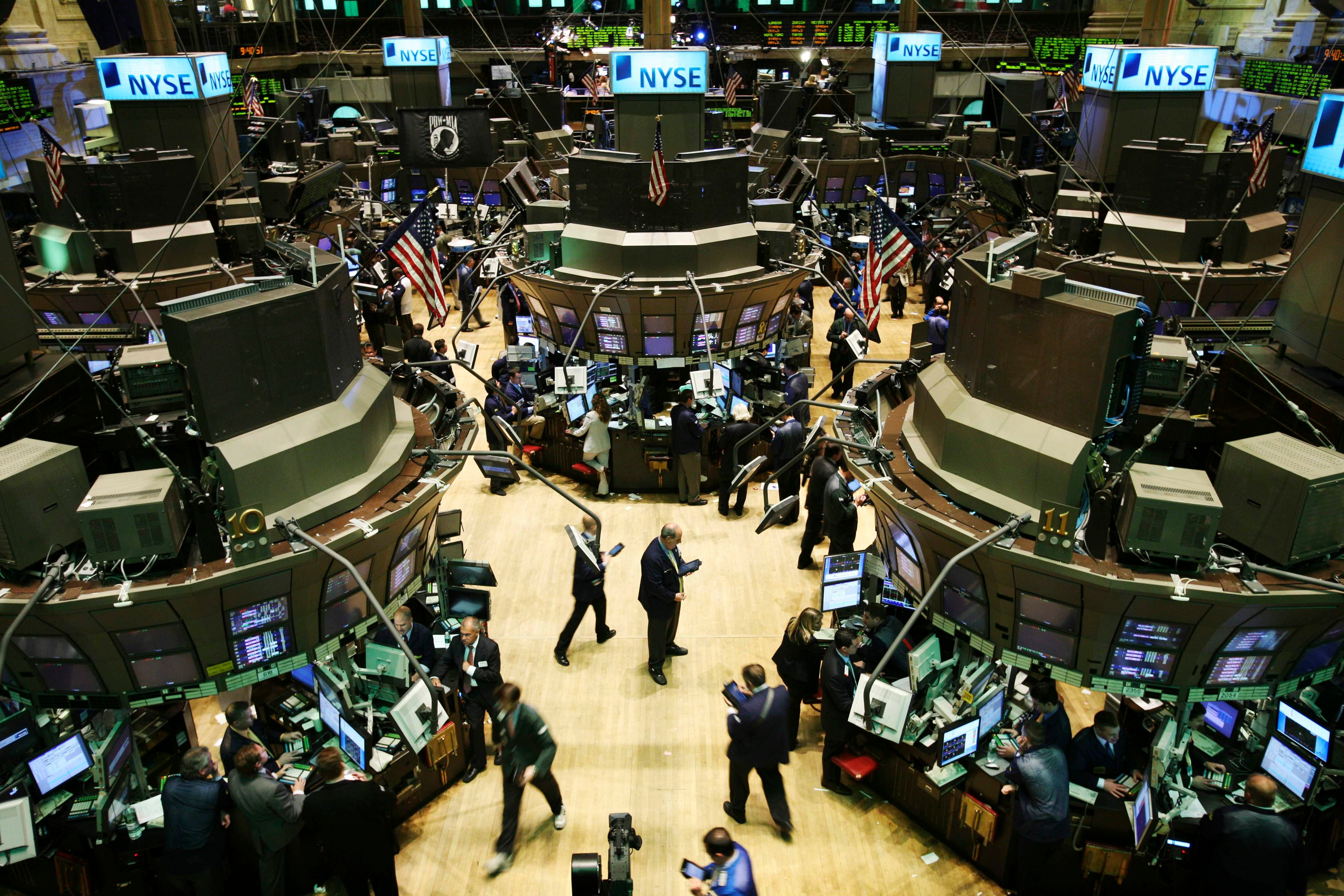 Handelsgolvet på New York Stock Exchange med handlare vid sina arbetsplatser och amerikanska flaggor.