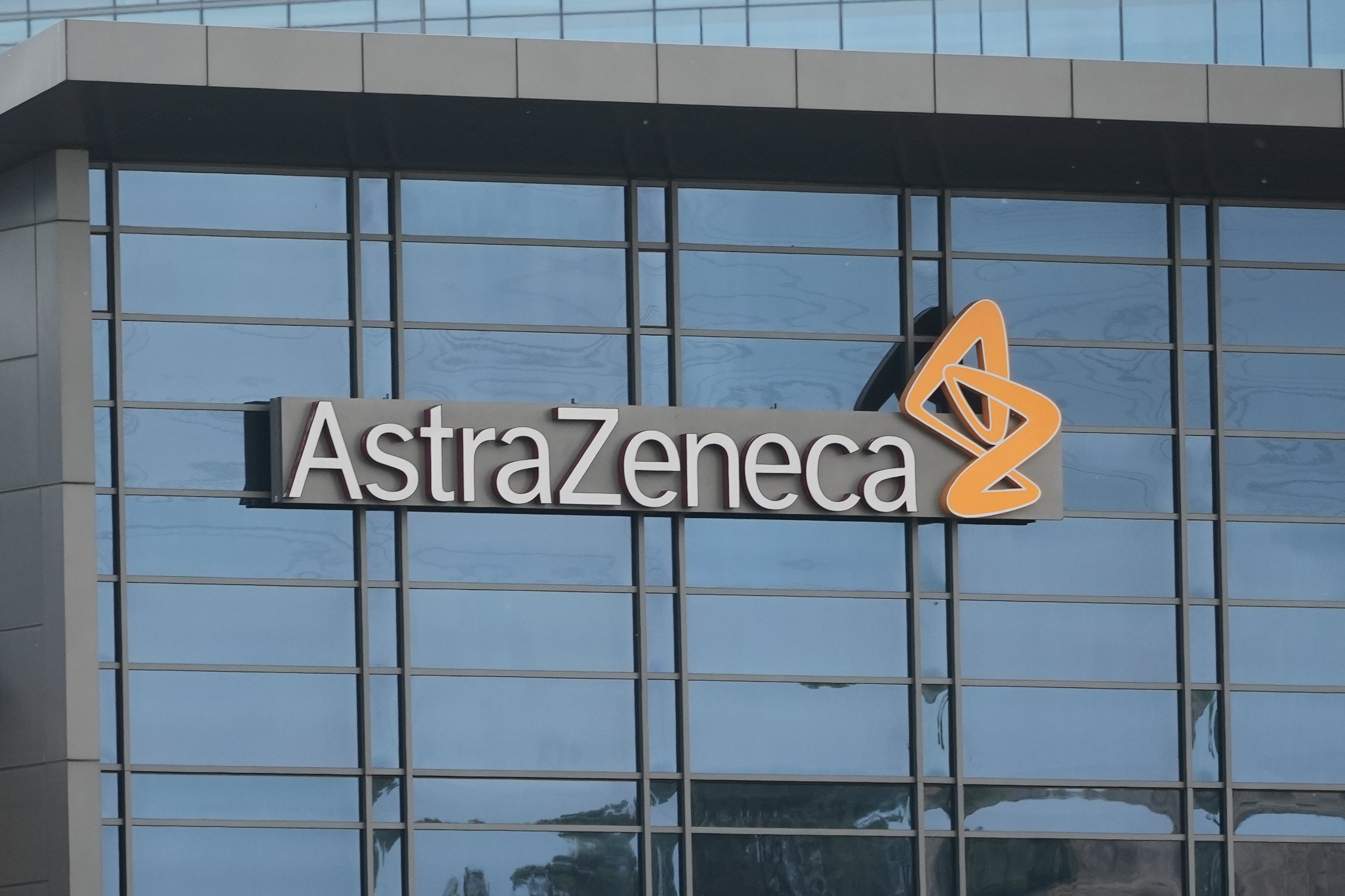 AstraZenecas företagslogga på en byggnadsfasad med stora fönster.