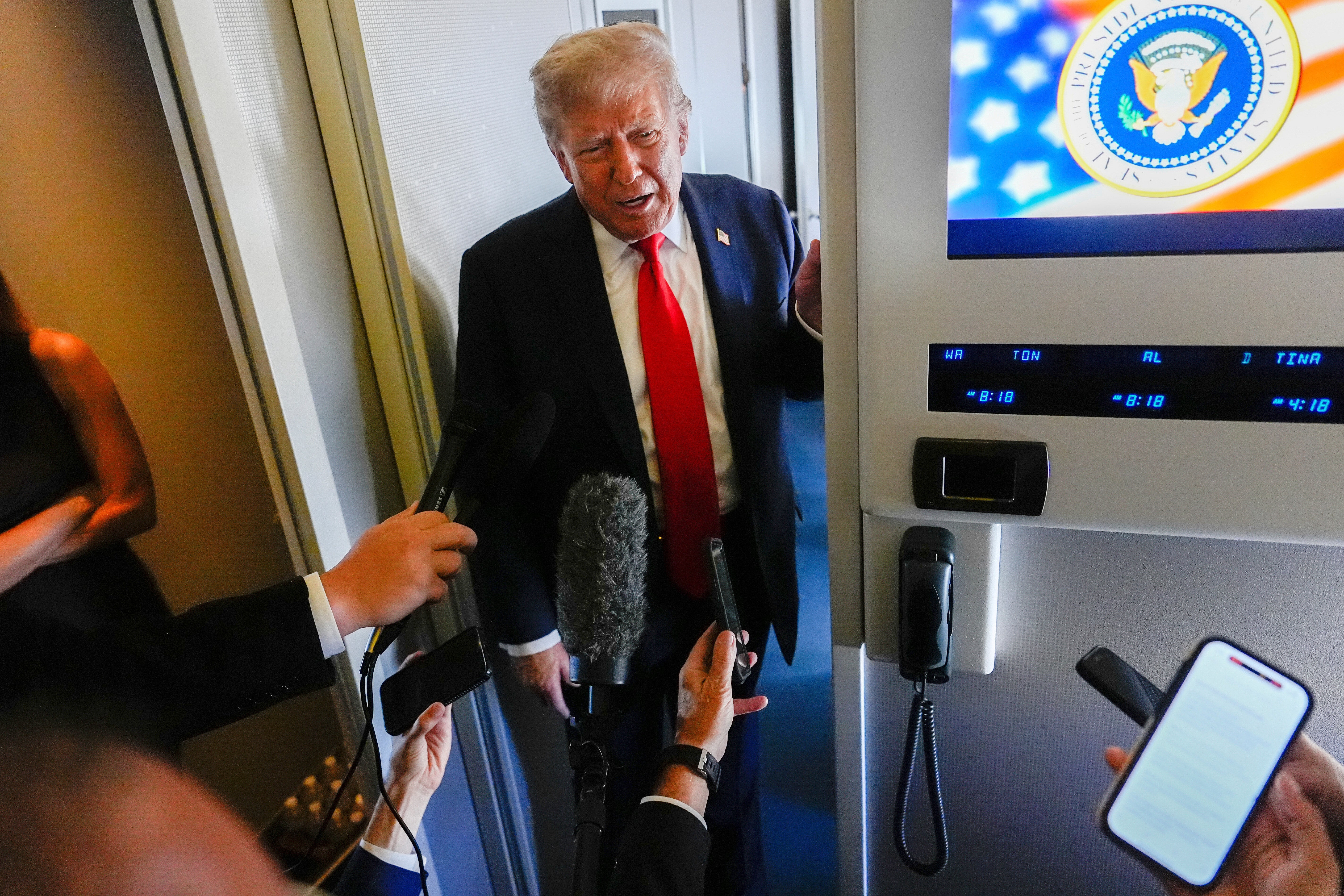 Trump möter reportrarna i Alaska som står med mikrofonerna i högsta hugg.