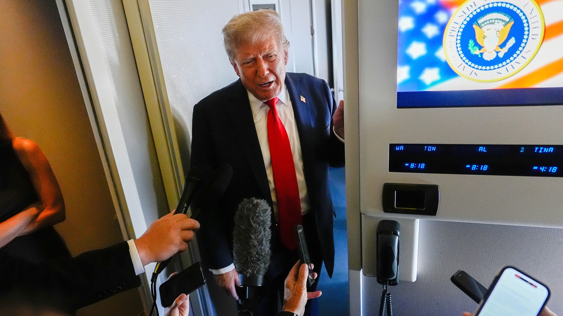 Trump möter reportrarna i Alaska som står med mikrofonerna i högsta hugg.