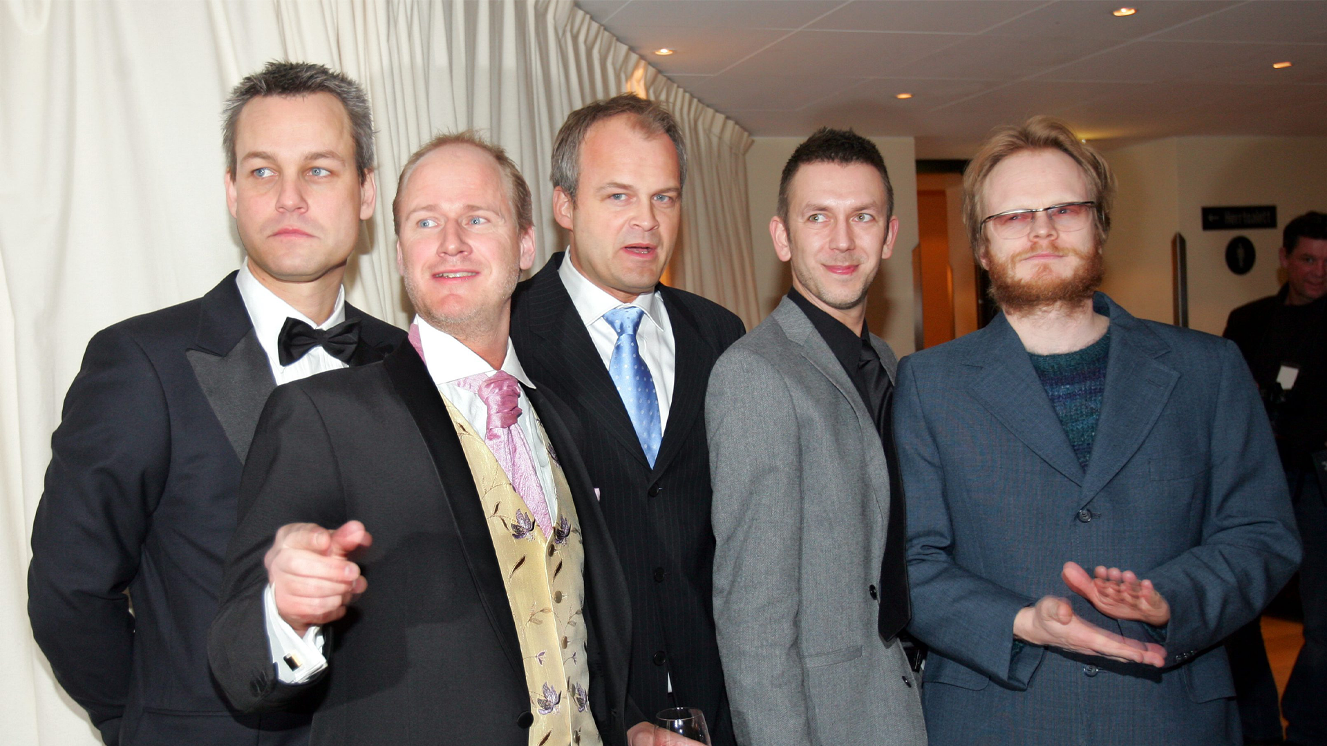 Fem män i formell klädsel står tillsammans inomhus för ett gruppfoto.
