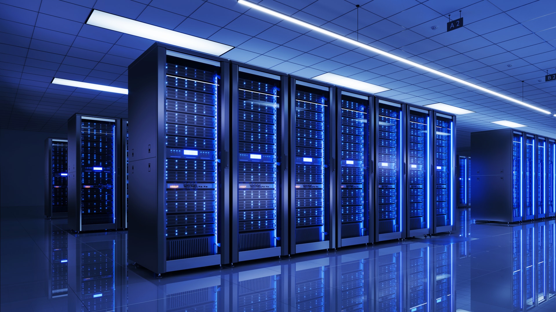 Ett datacenter med rader av serverskåp upplysta i blått ljus.