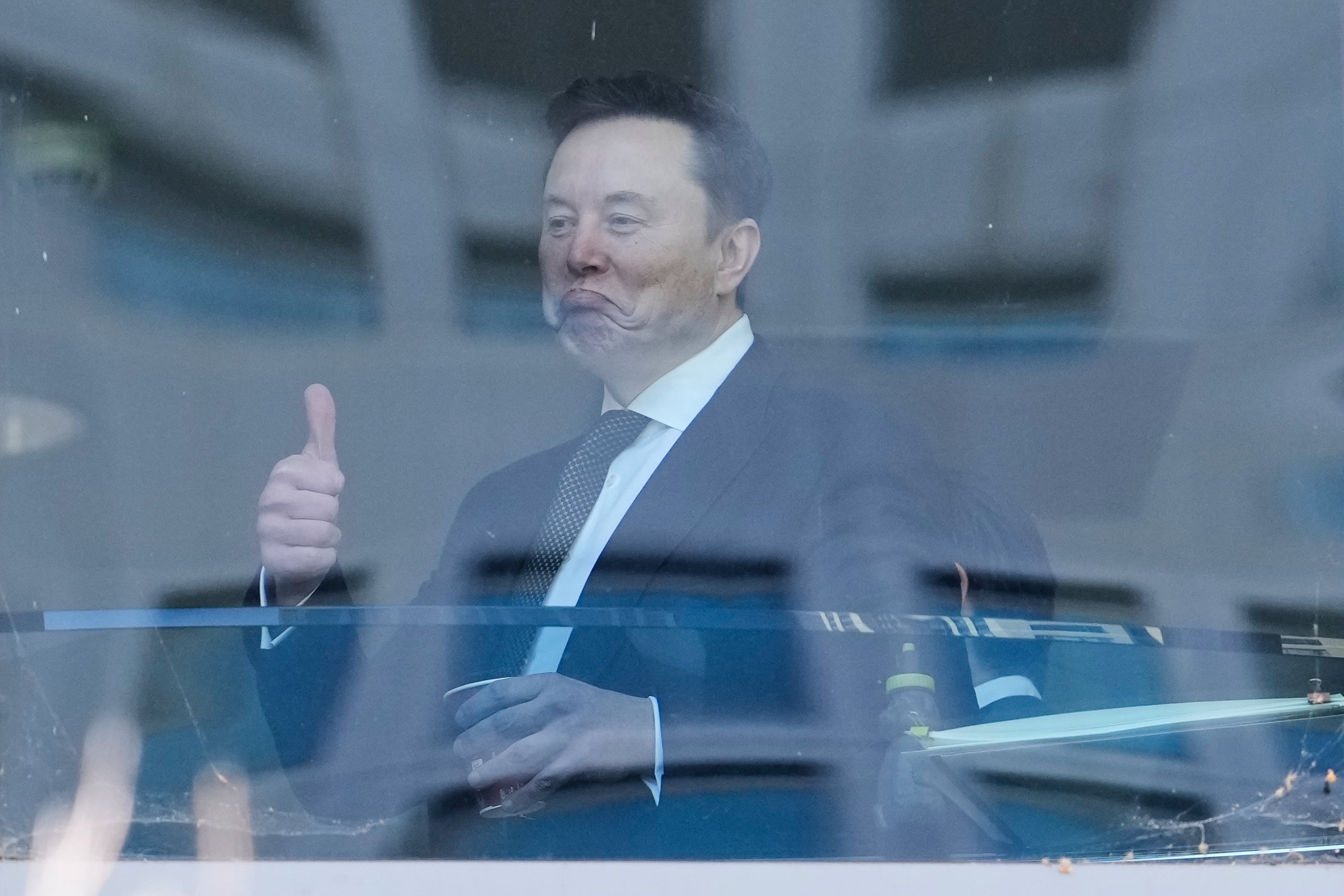 Man i kostym ger tummen upp framför grafiska data-visualiseringar