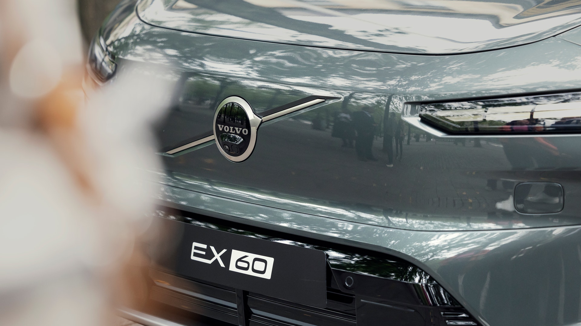 Närbild av fronten på en Volvo EX60 med Volvo-emblemet och modellnamnet.