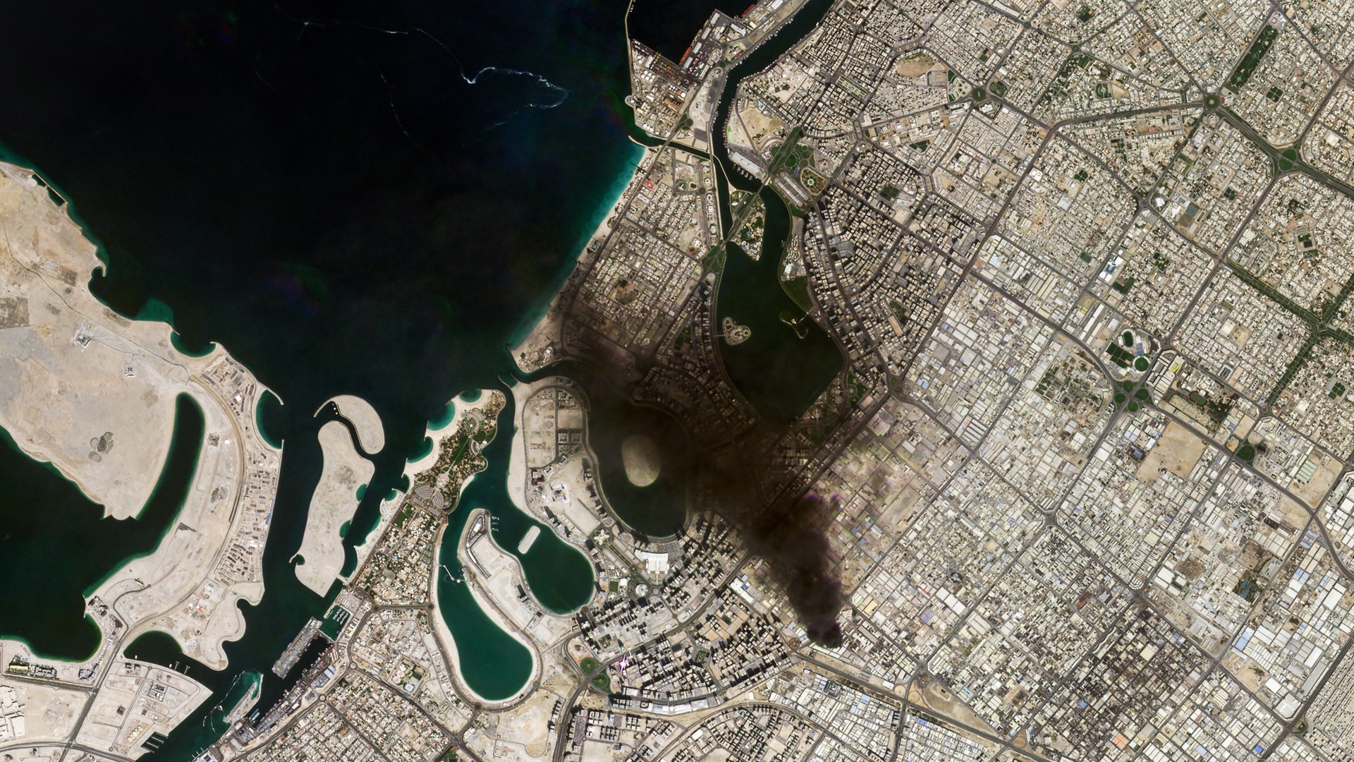 Flygfoto över en kuststad med stadsplanering och vatten