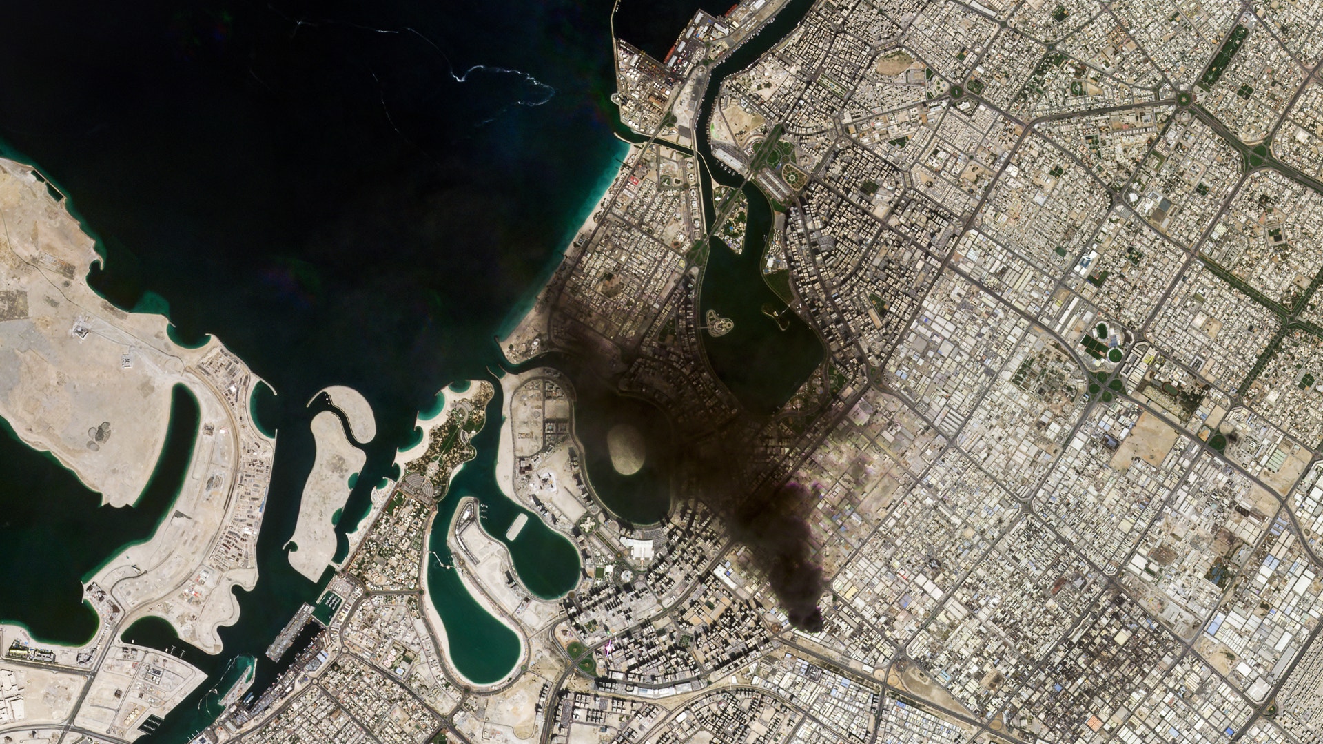 Flygfoto över en kuststad med stadsplanering och vatten