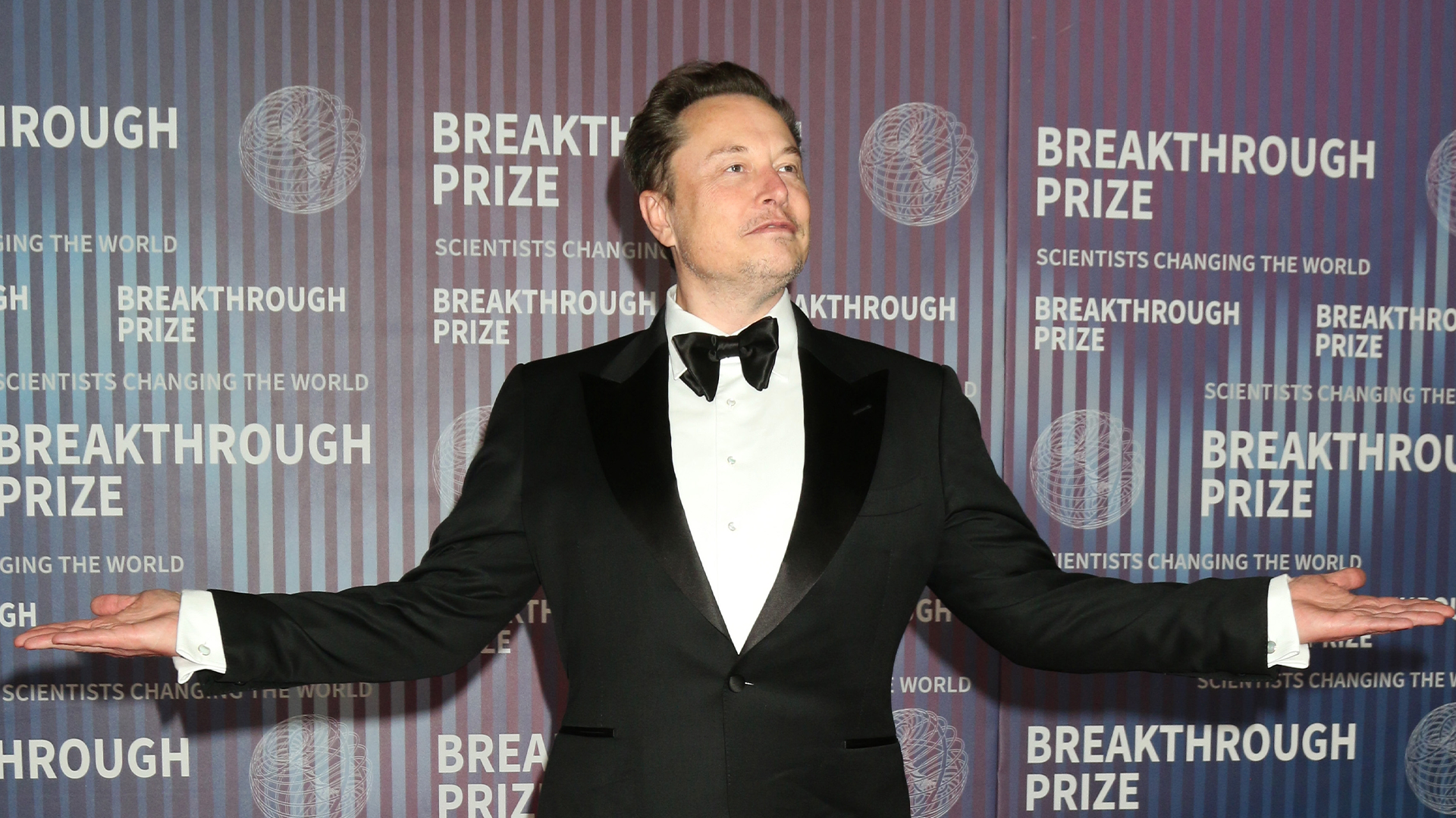 Man i smoking och fluga framför Breakthrough Prize-bakgrund