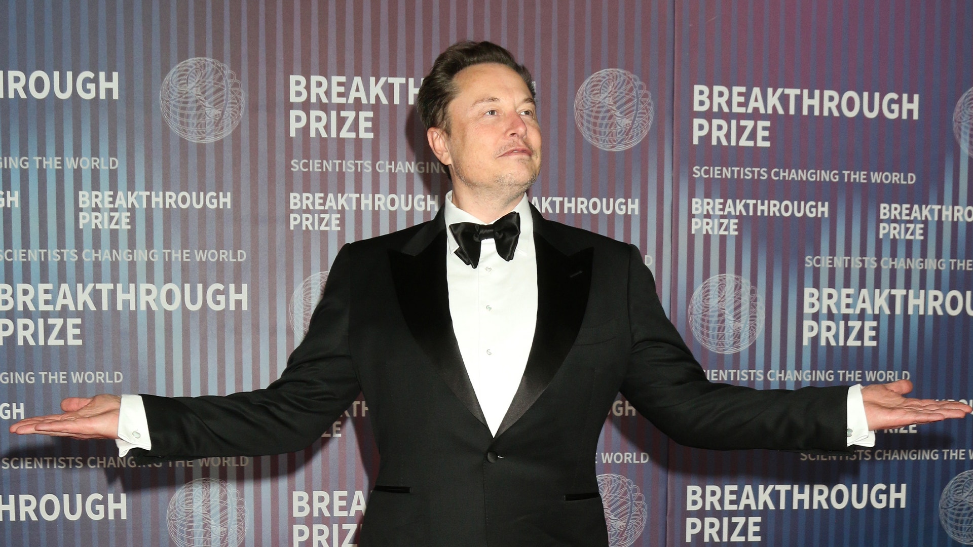 Man i smoking och fluga framför Breakthrough Prize-bakgrund
