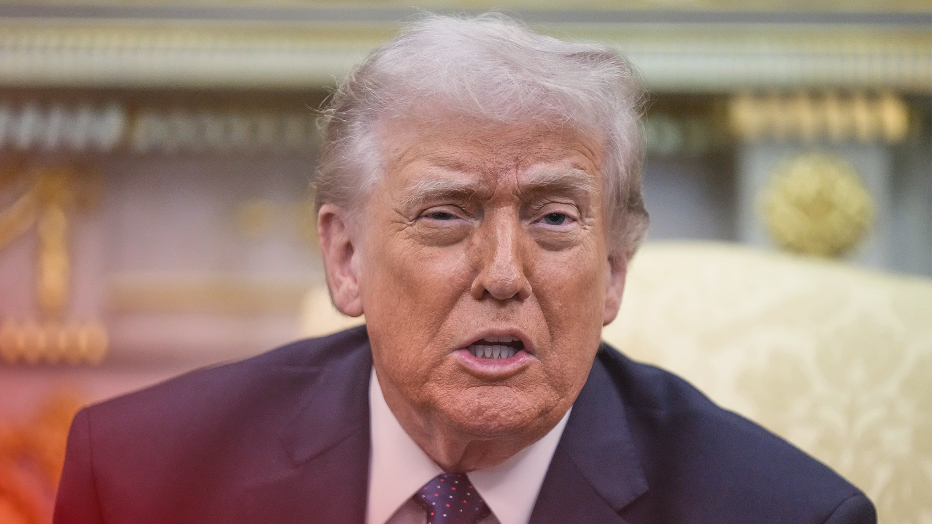 Porträtt av en man i mörkblå kostym och röd slips