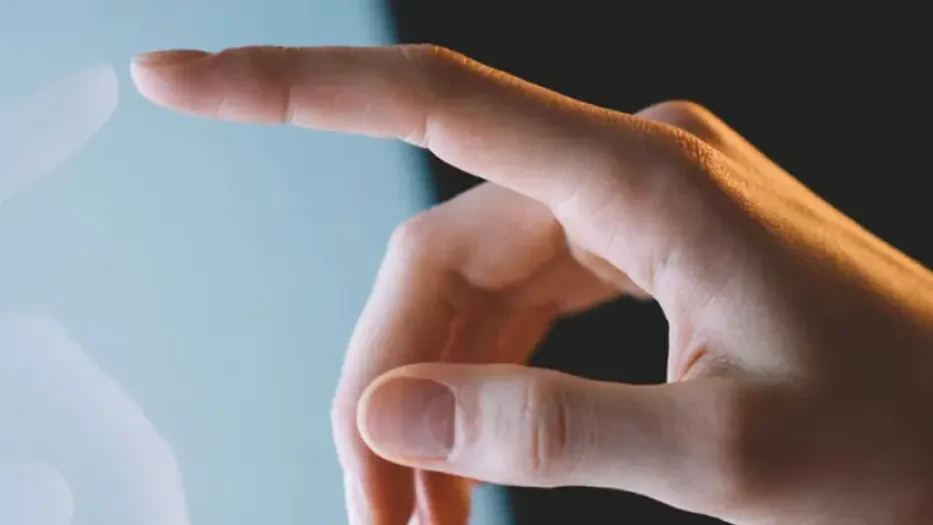 Ett finger som pekar på en skärm, samt en mindre bild på Gustav Brismark.