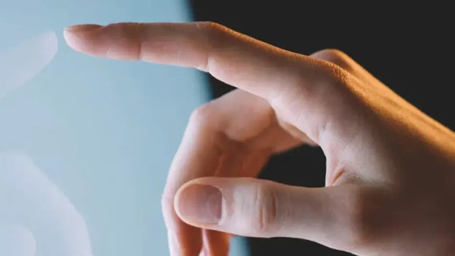 Ett finger som pekar på en skärm, samt en mindre bild på Gustav Brismark.