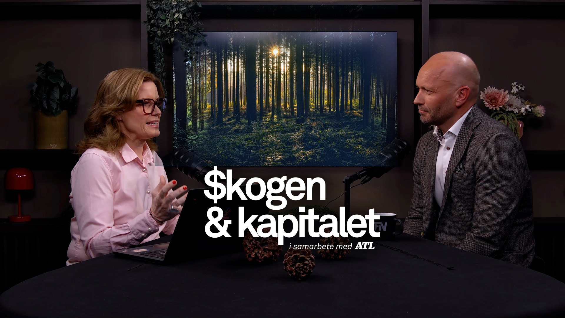 Två personer i en studiomiljö diskuterar framför en skärm med en skogsbild. Text på skärmen säger "$kogen & kapitalet".