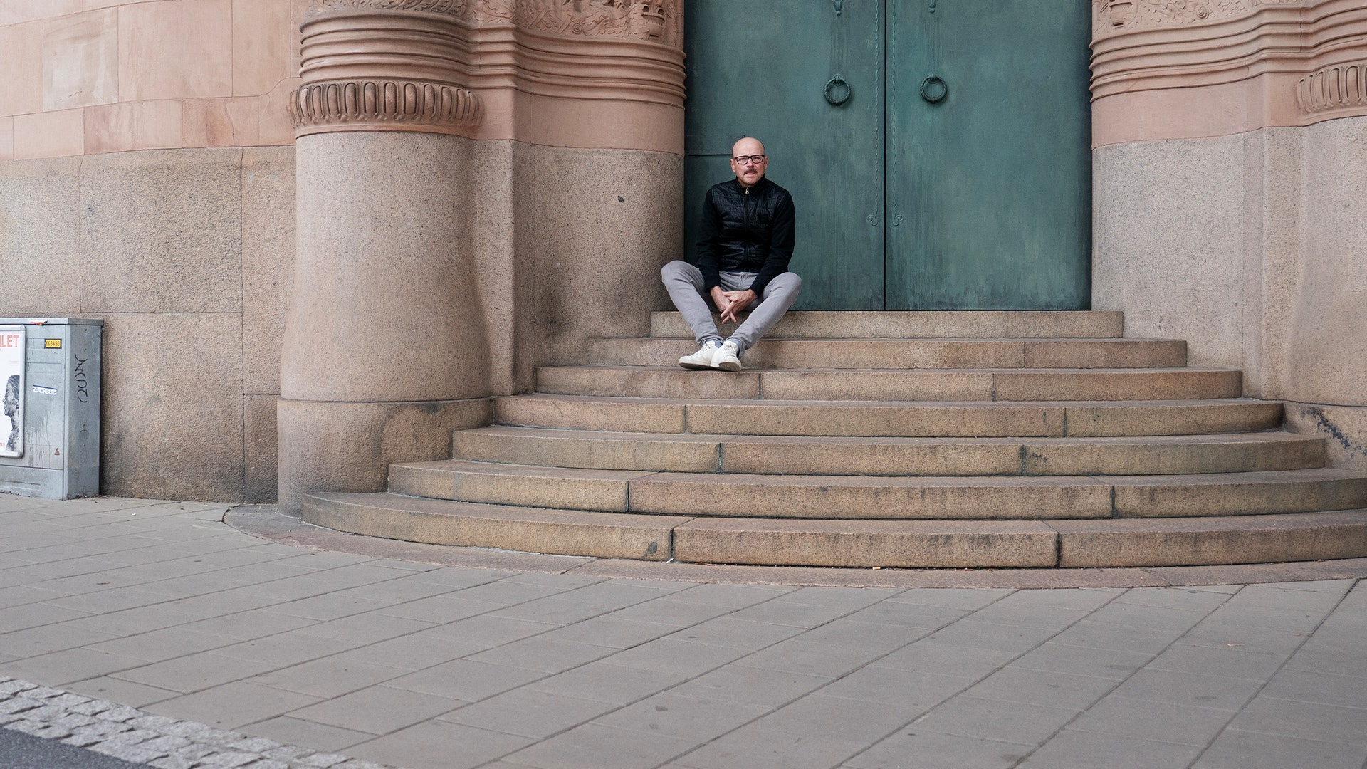 Pål Ahlsén sitter på en trappa upp till porten utanför Castellums kontor.