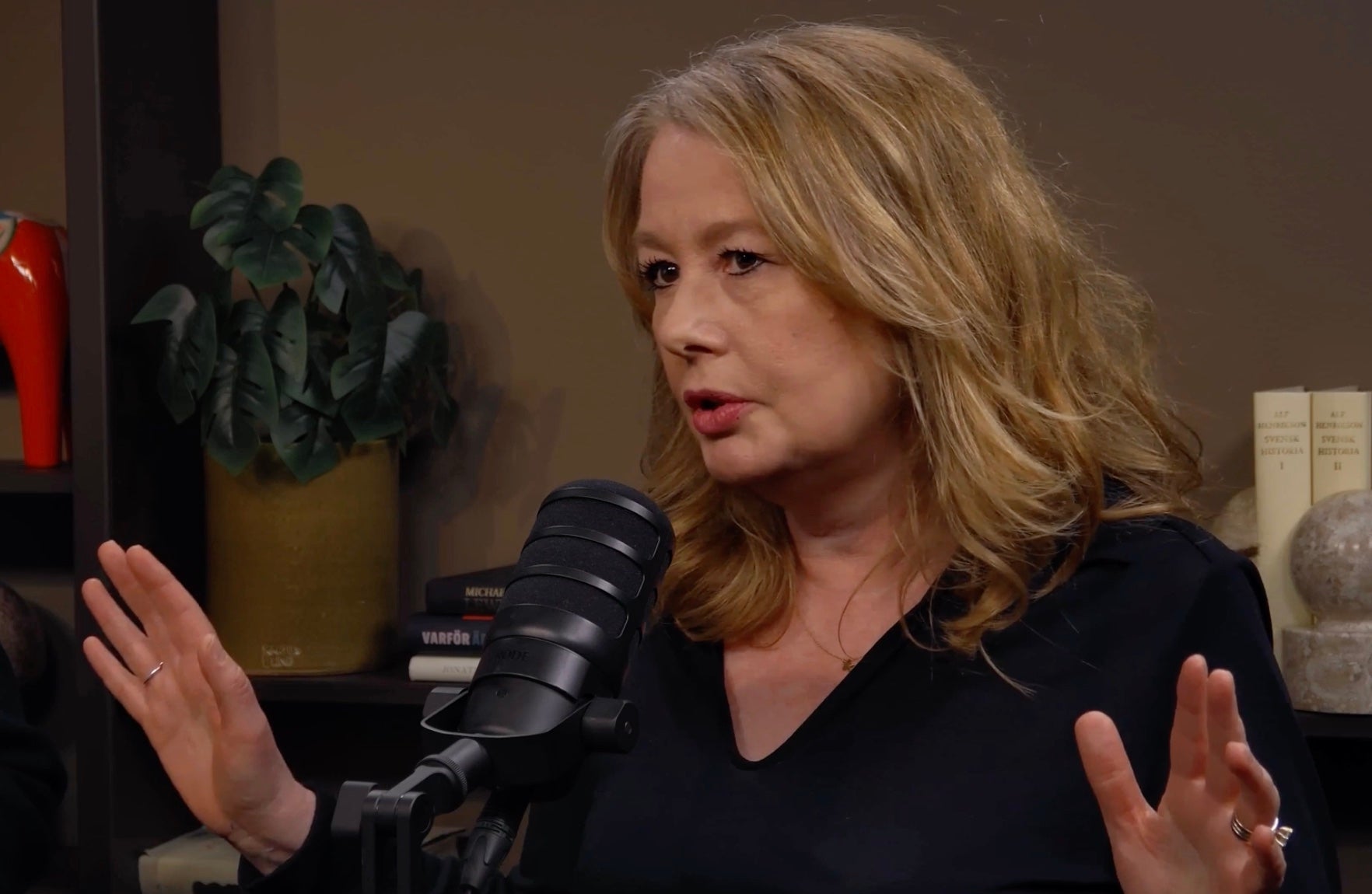 Kvinna talar in i en mikrofon under en podcast eller intervju.