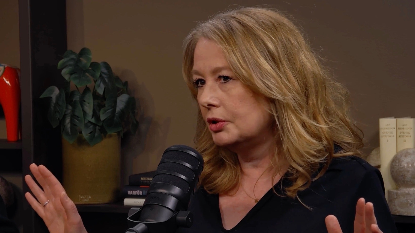 Kvinna talar in i en mikrofon under en podcast eller intervju.