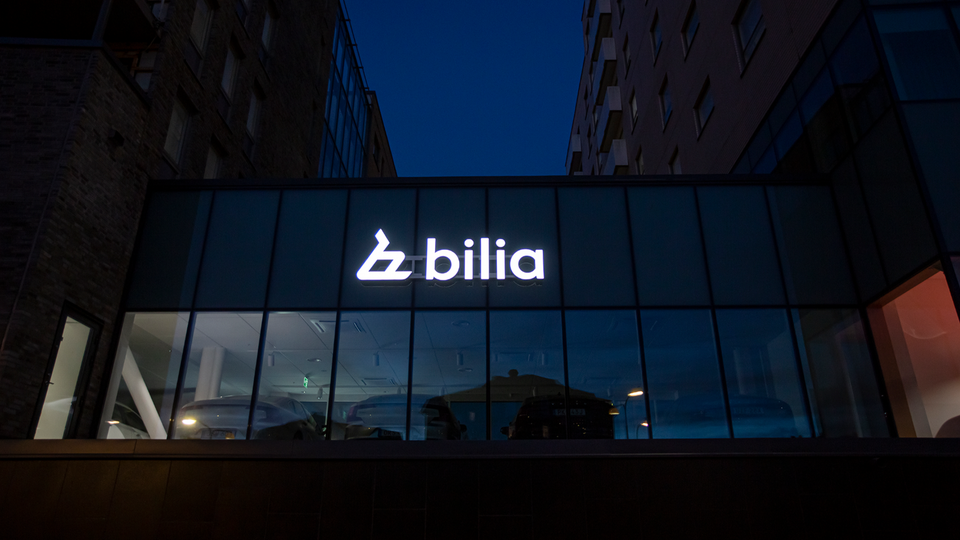 Bilia-logotyp på en modern byggnad belyst på kvällen