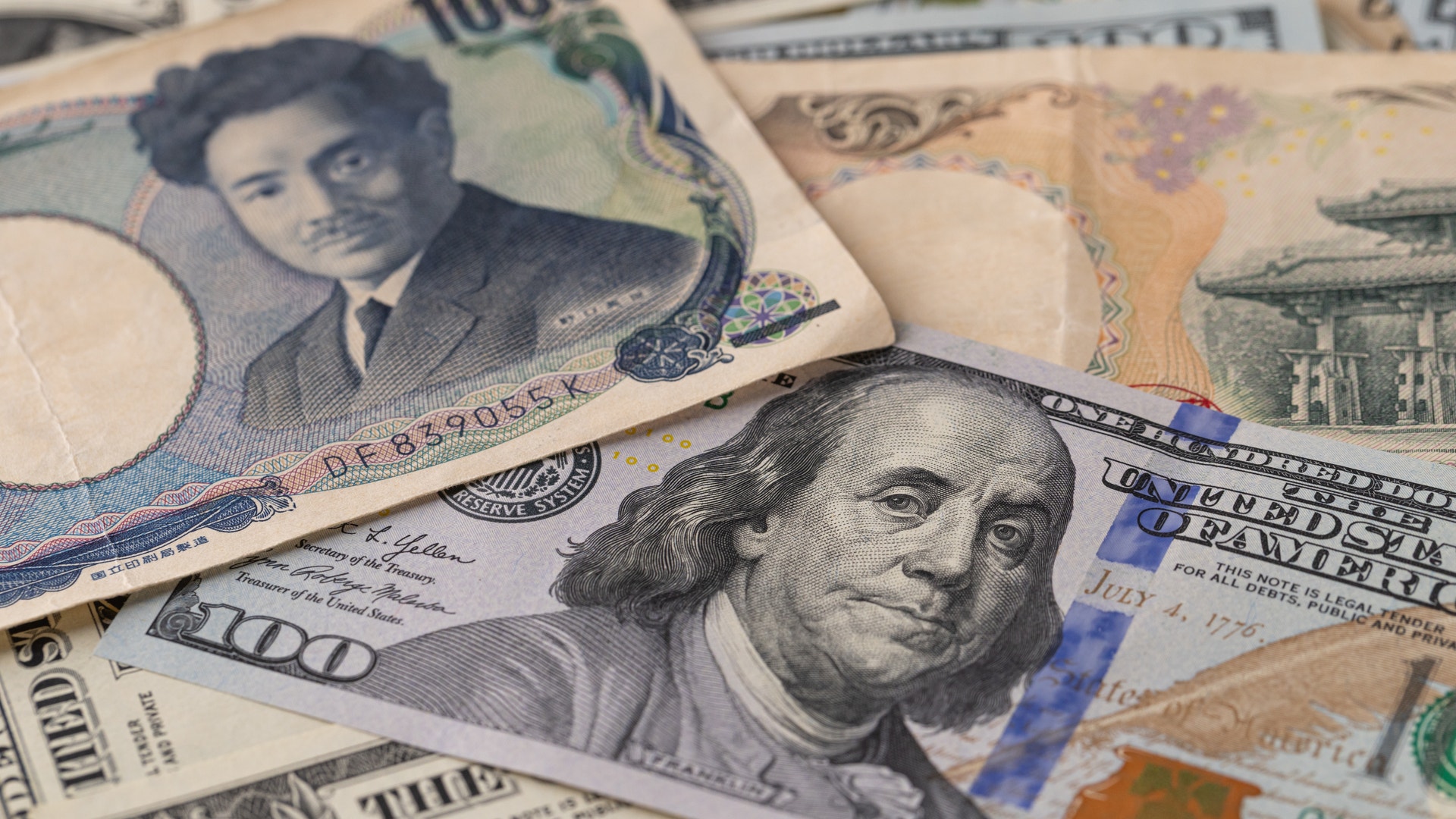 Japanska yenasedlar och amerikanska dollarsedlar överlappade på varandra.