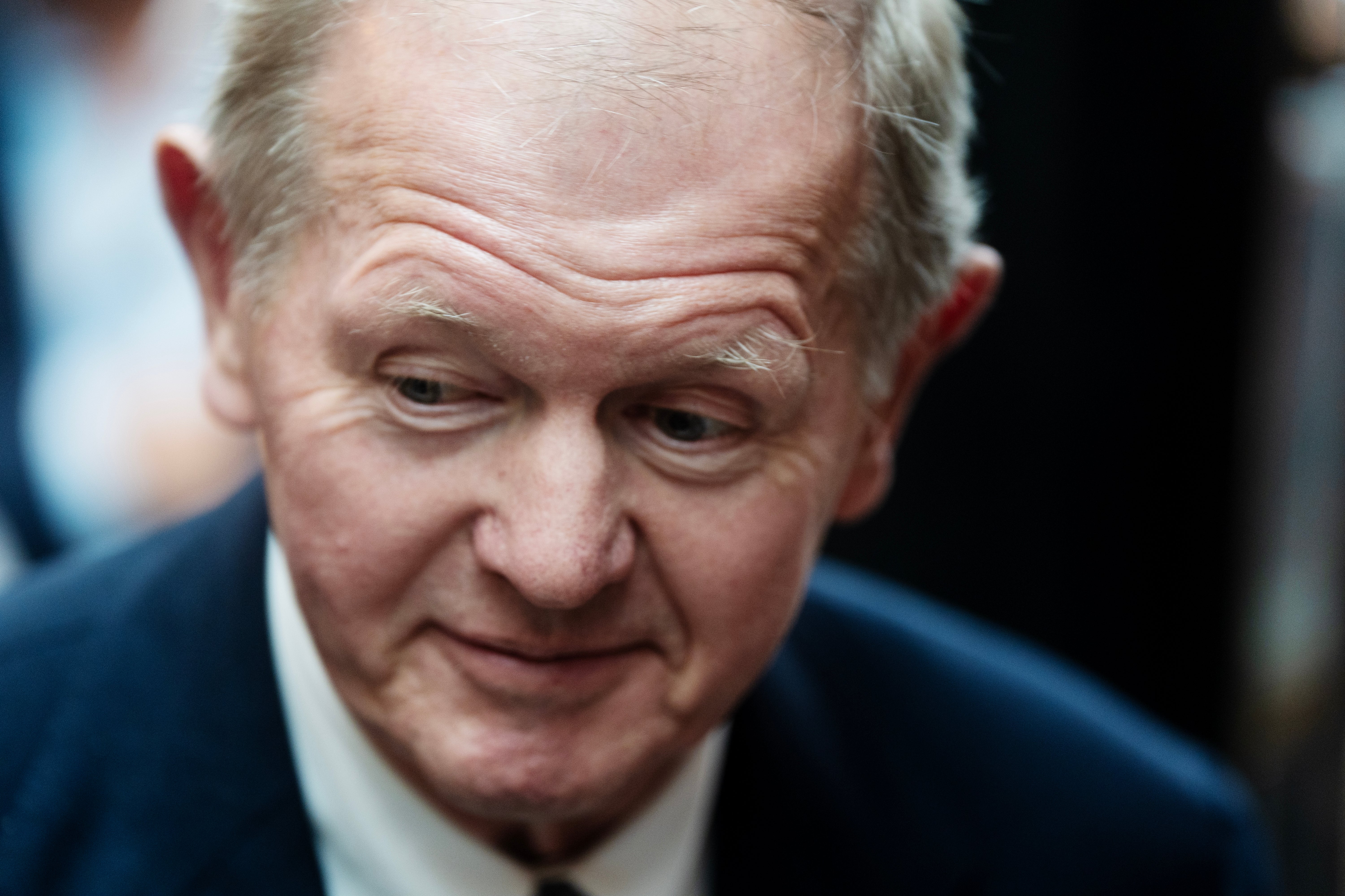 Porträtt av äldre man i mörk kostym och vit skjorta