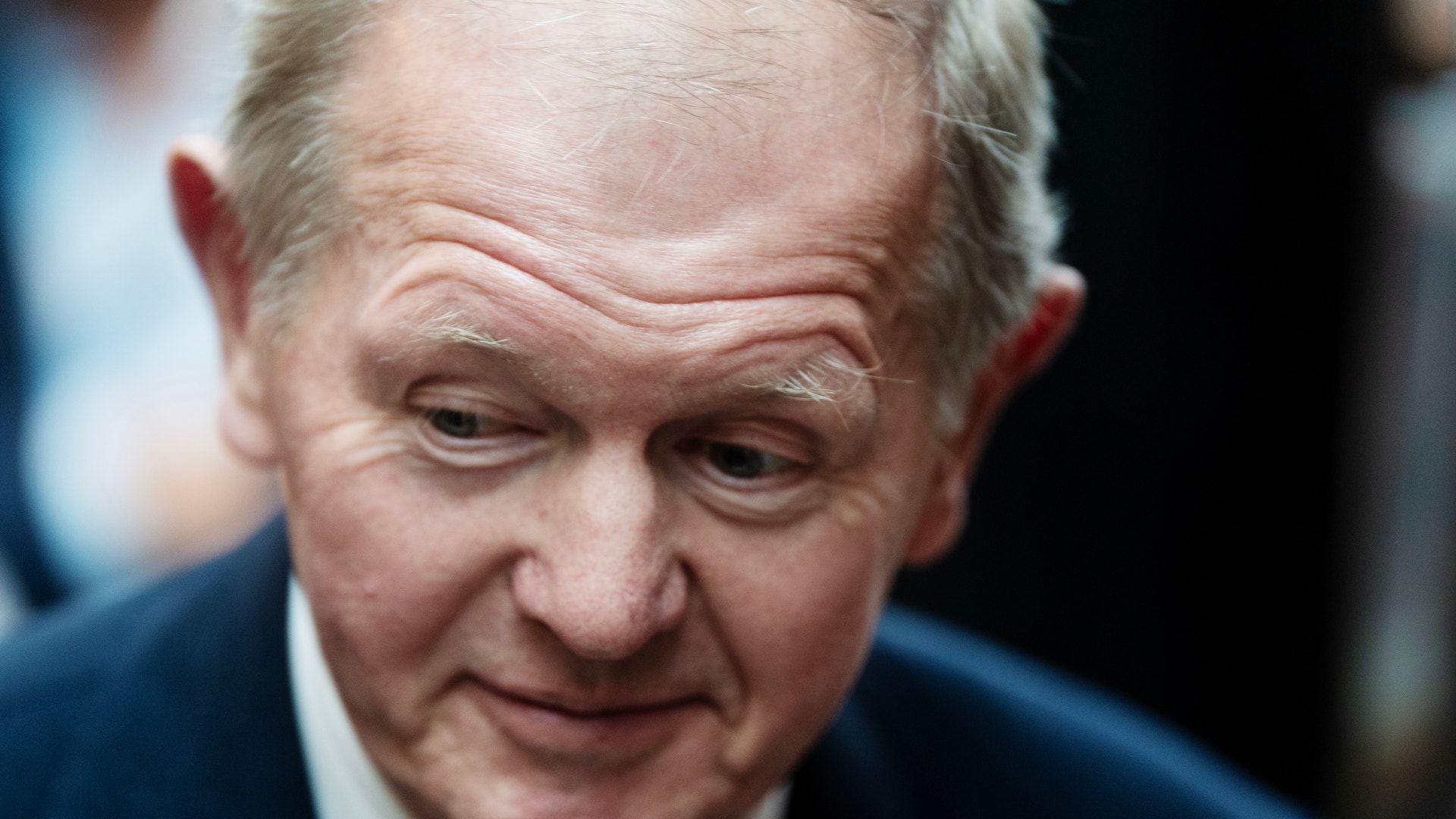Porträtt av äldre man i mörk kostym och vit skjorta