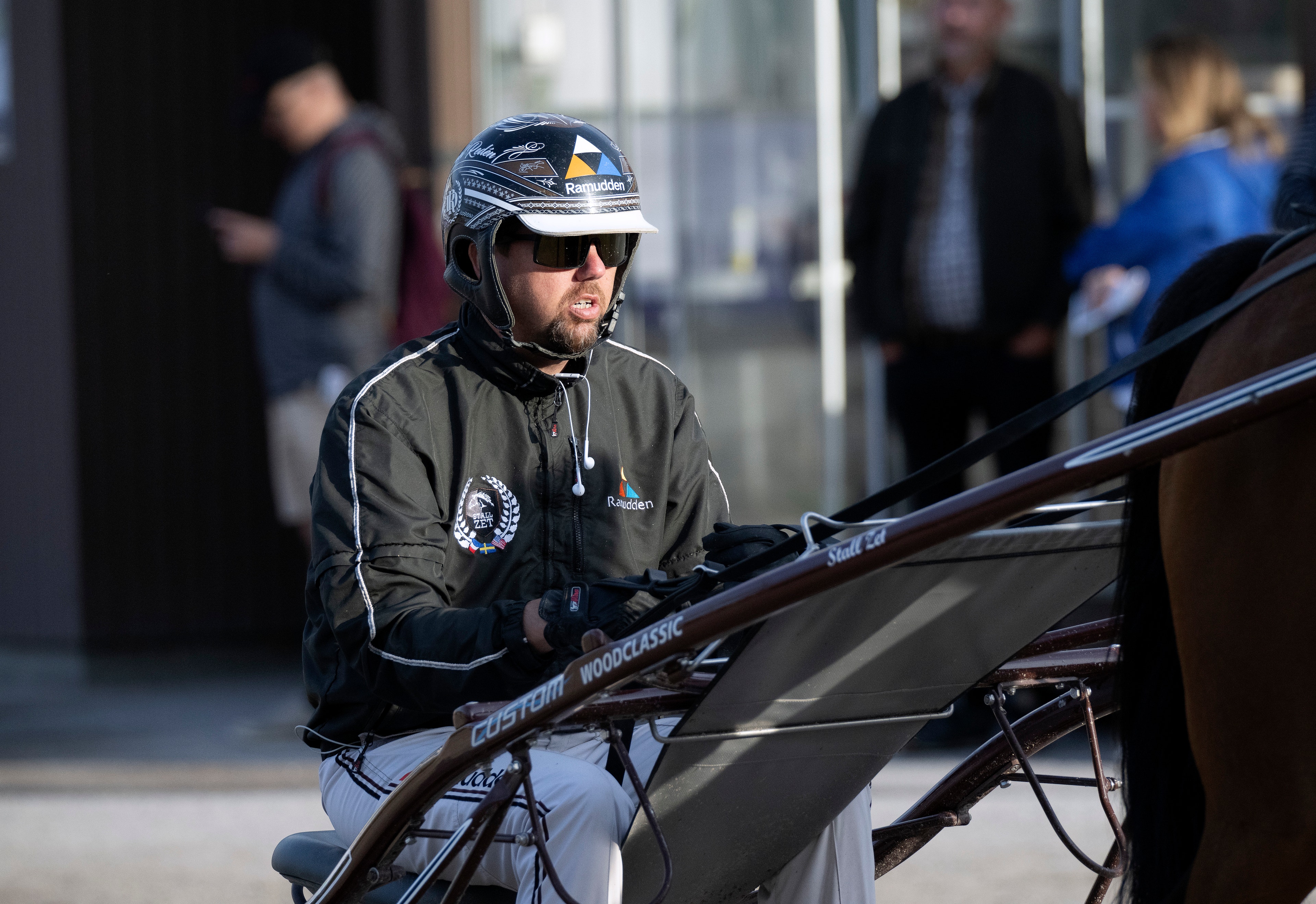 En man på en cykel bär cykelhjälm och solglasögon på en stadsgata.