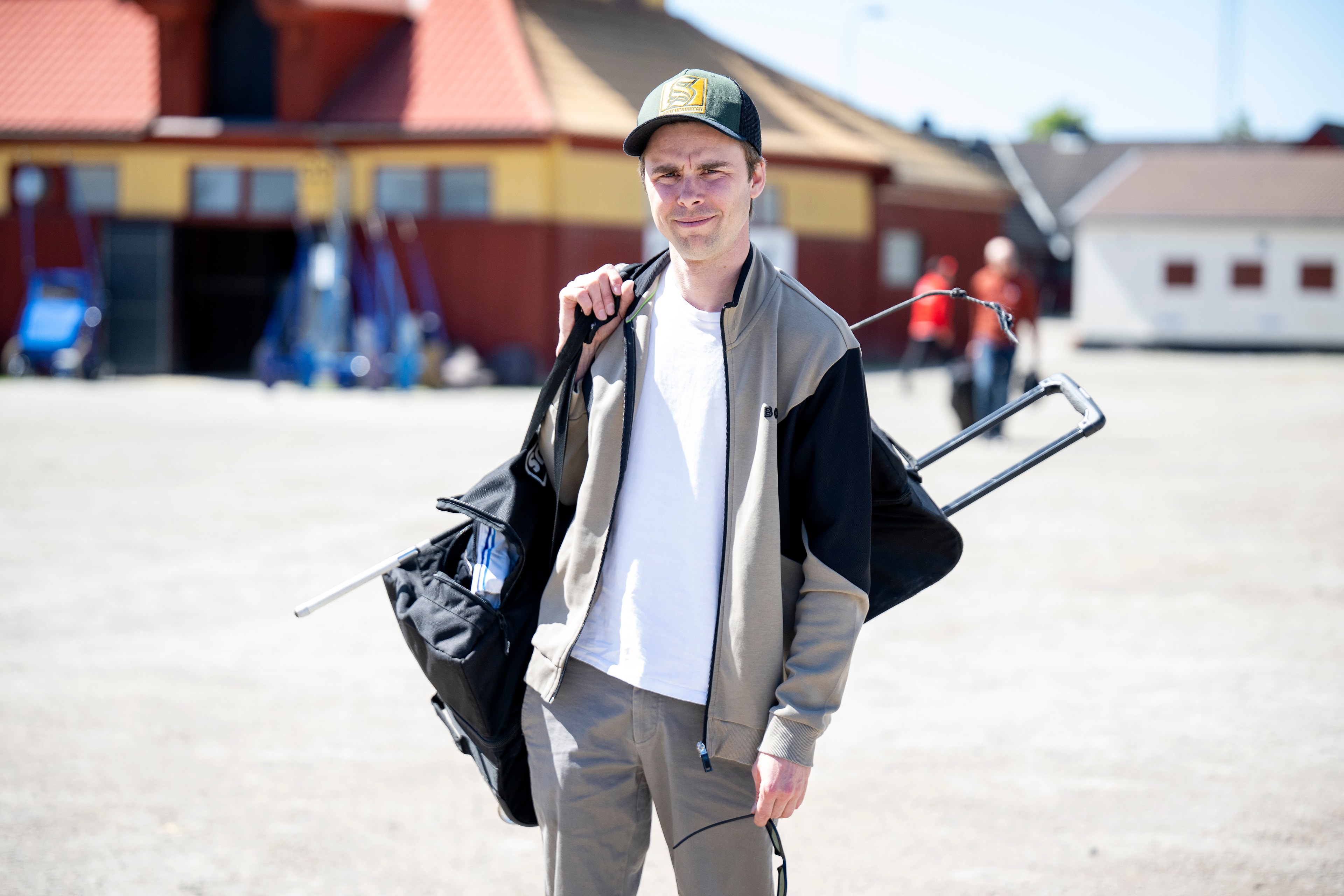 Porträtt av en man i arbetskläderna som står på en gård och håller i verktyg.

Daniel Wäjersten