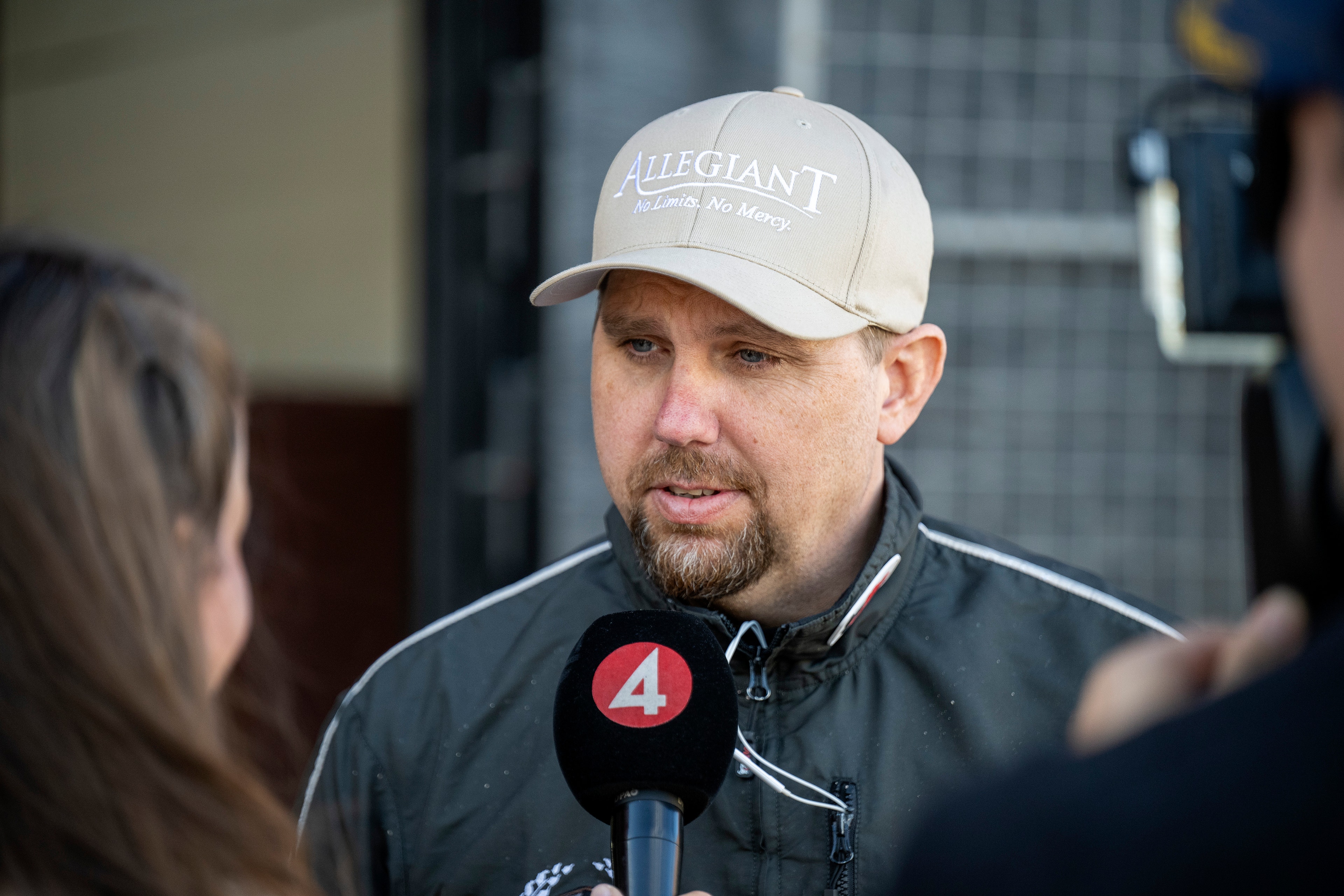 Man med vit keps blir intervjuad med en mikrofon.